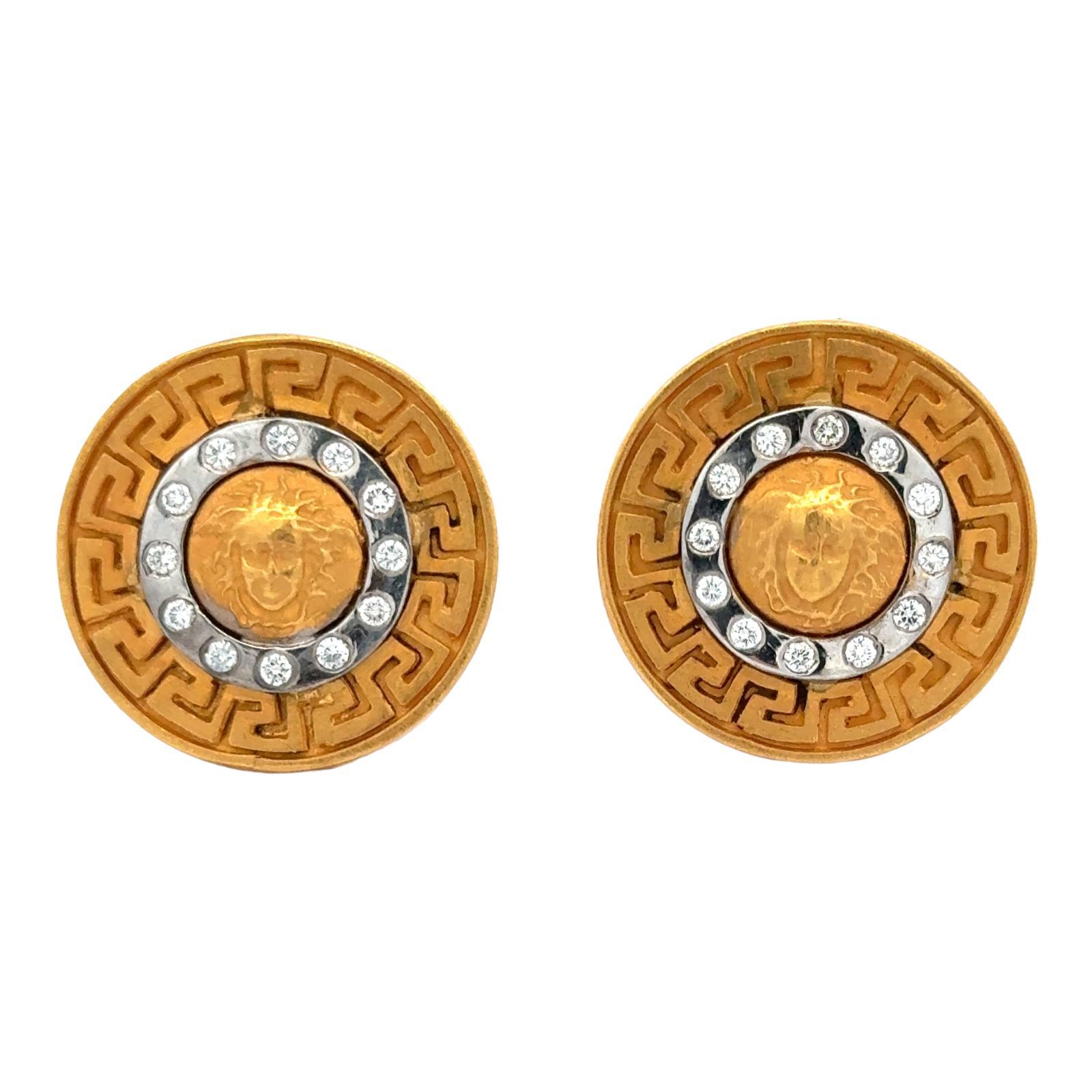 Greek key and medusa design diamond cufflinks crafted in 21 karat yellow gold. The cufflink findings are 14 karat yellow gold. Twenty four round brilliant cut diamonds weigh approximately .48 CTW and are graded G-H color and SI clarity. The