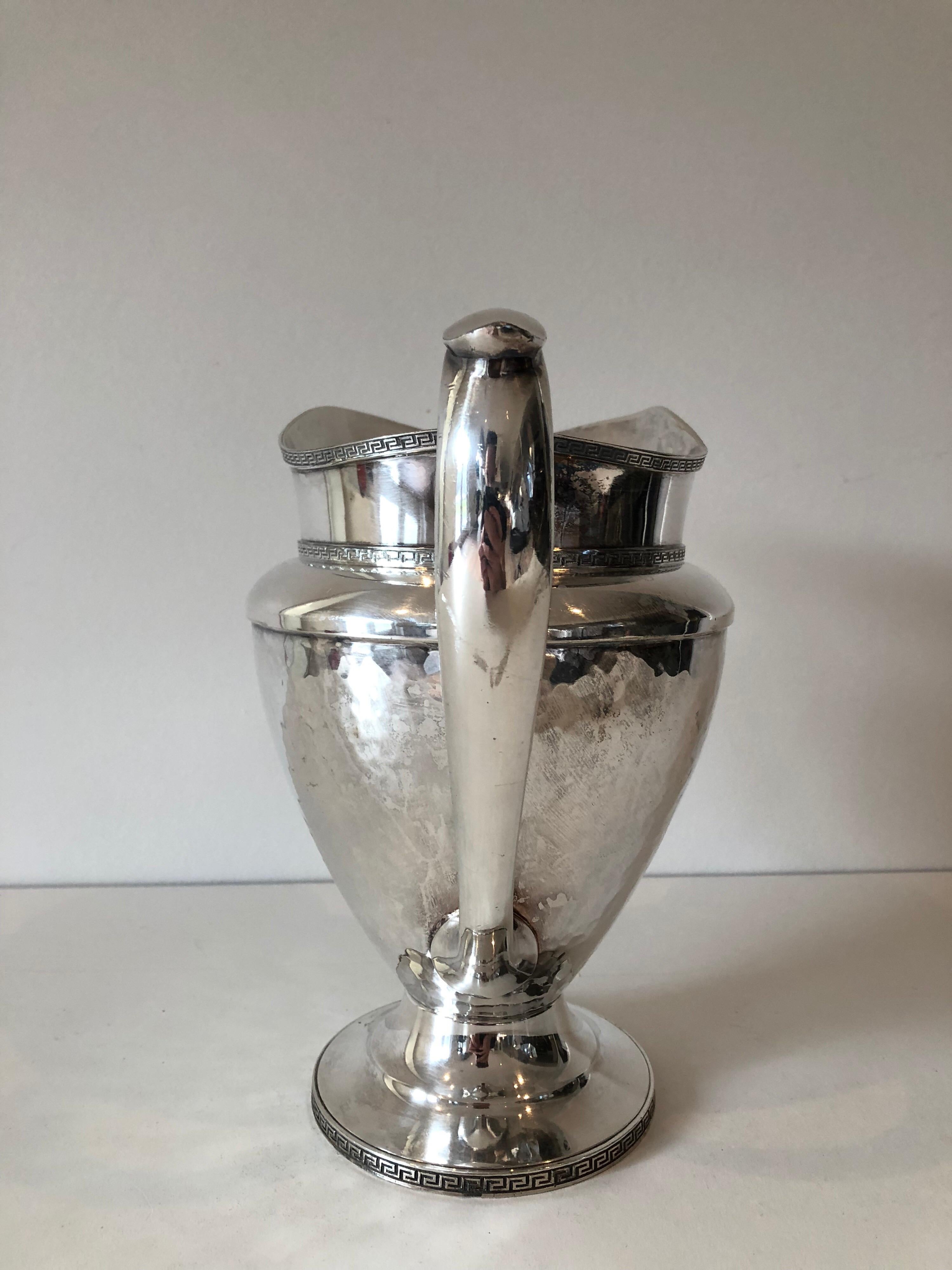 A vintage silver plated nickel pitcher with Greek key design throughout.