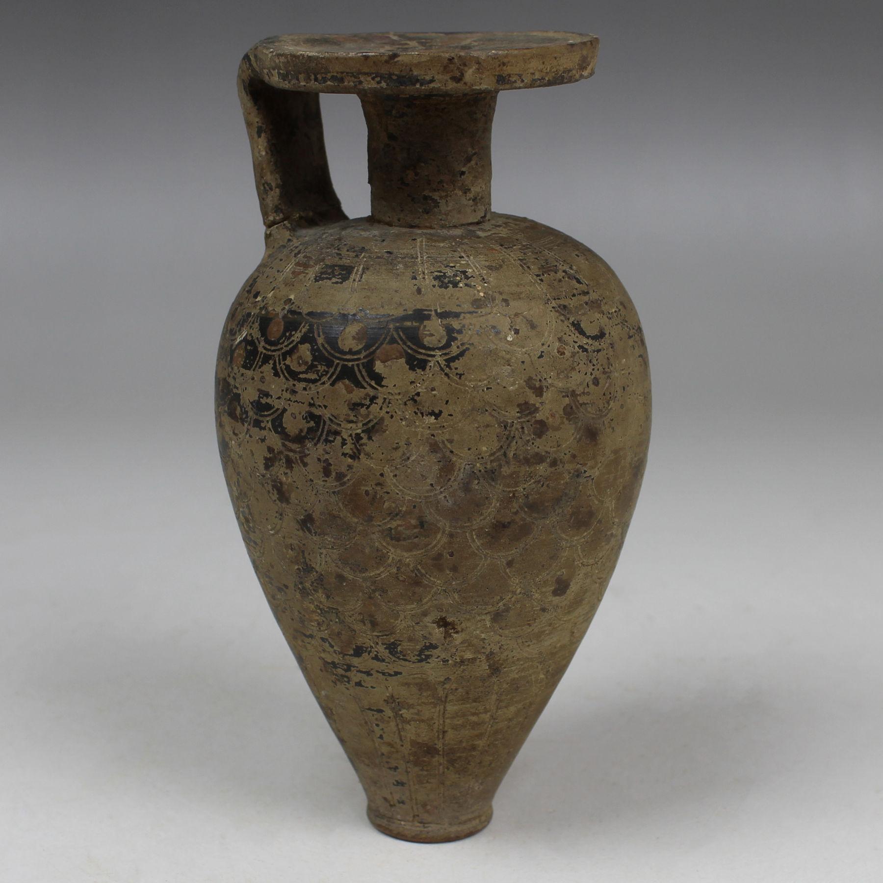 ITEM: Piriform aryballos with scale pattern
MATERIAL: Pottery
CULTURE: Greek, Corinthian
PERIOD: 7th Century B.C
DIMENSIONS: 116 mm x 57 mm
CONDITION: Good condition, handle repaired
PROVENANCE: Ex Swiss private collection, M. H. D., acquired