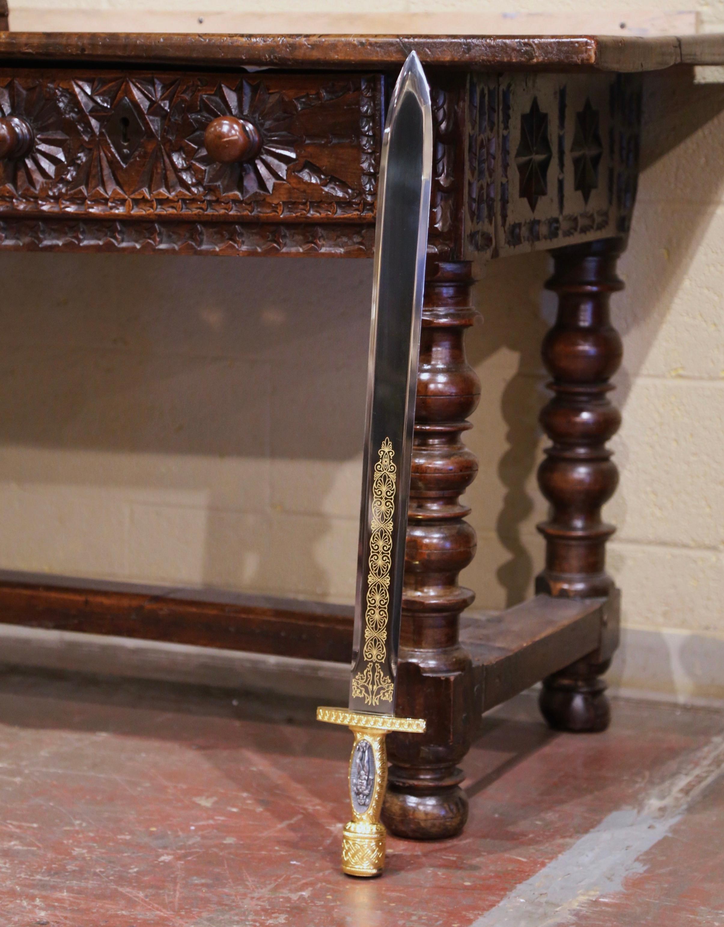 Die antike Klinge im klassischen Xiphos-Stil wurde um das Jahr 2000 in Griechenland hergestellt. Das Schwert aus der alten Welt hat eine zweischneidige Klinge mit zwei Greifen und aufwändigen Motiven auf beiden Seiten. Der Griff zeigt eine