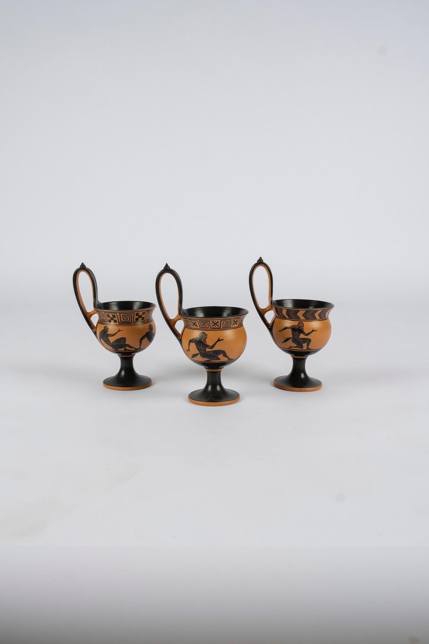 Mid 20th century Atica terra cotta kyathos cup featuring early Classical Greek scenes. This long handle stemmed pottery cup was  used for drinking wine. Sold individually, $995 each.