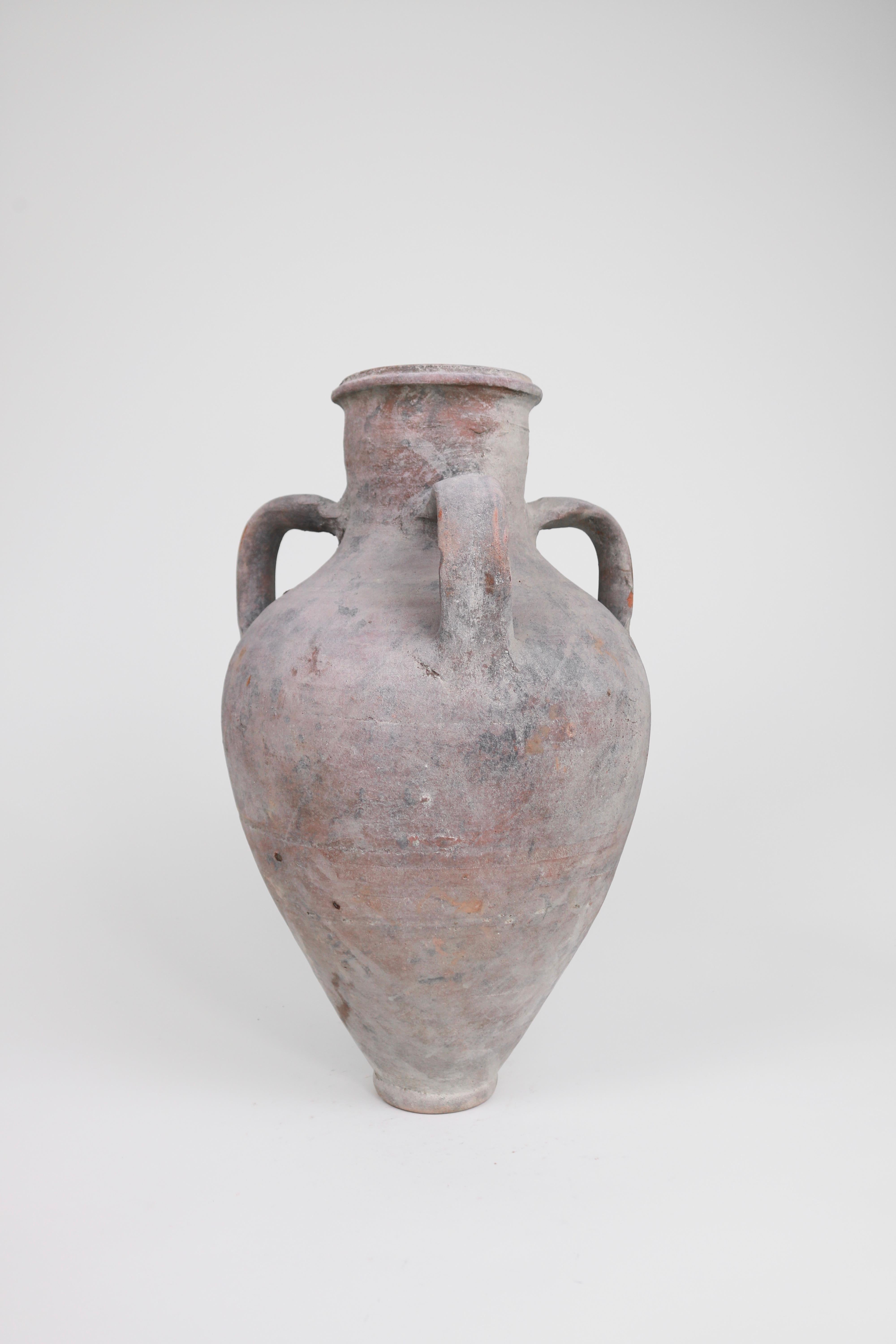 This 3-armed Greek amphora was once used to store and transport liquids in the early 1900s. With an elegantly tapered form and unusual 3-arms, this dusty-hued amphora makes a beautiful display piece. 

Coming from the Peloponnese area of Greece,