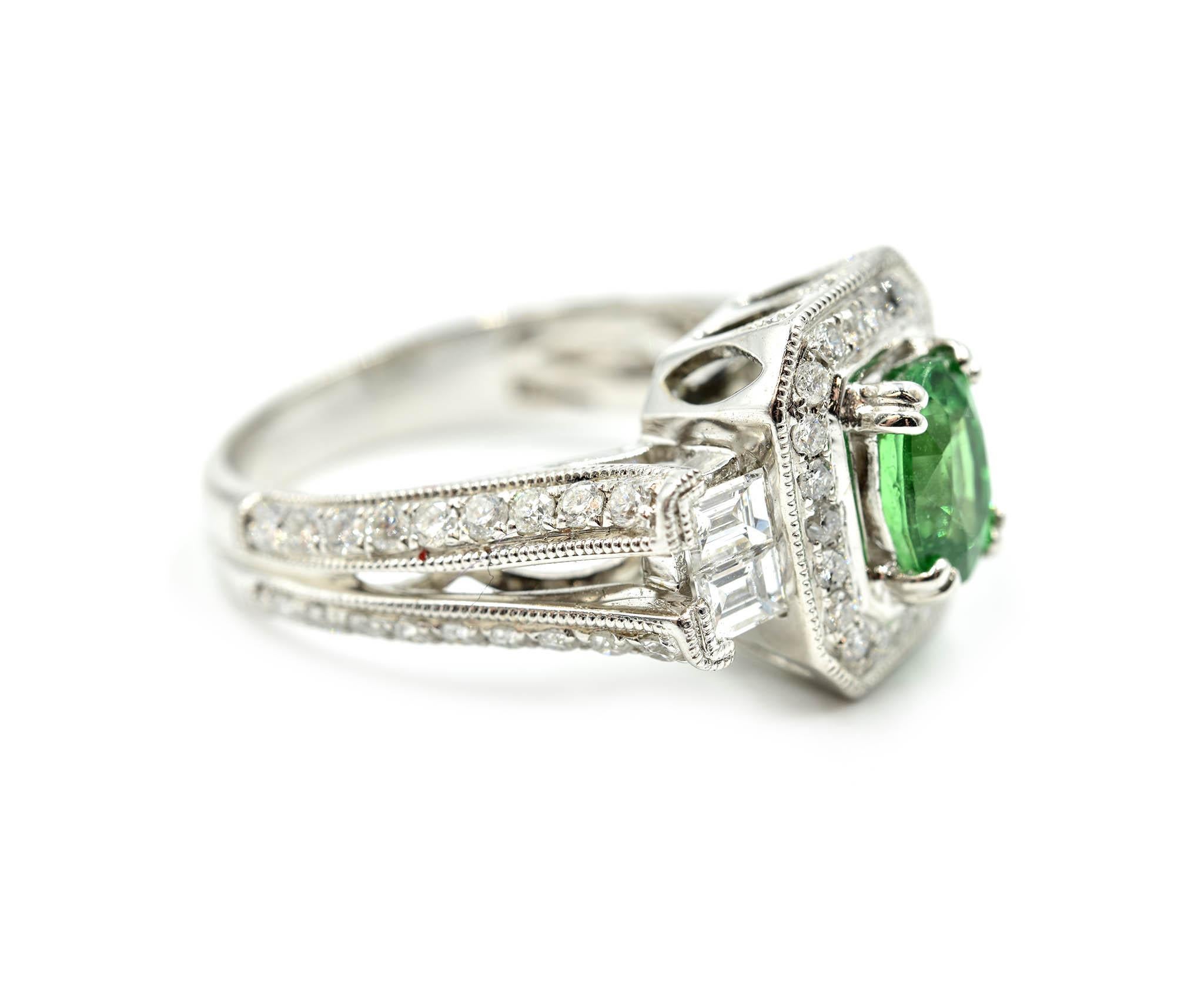 Designer: custom design
Material: 14k white gold
Tsavorite: green oval cut 1.33 carat tsavorite
Diamonds: 22 round brilliants and 4 baguette cuts = 1.65 carat total weight
Ring Size: 7 ¼ 
Dimensions: ring top measures 13.02mm long and 11.75mm