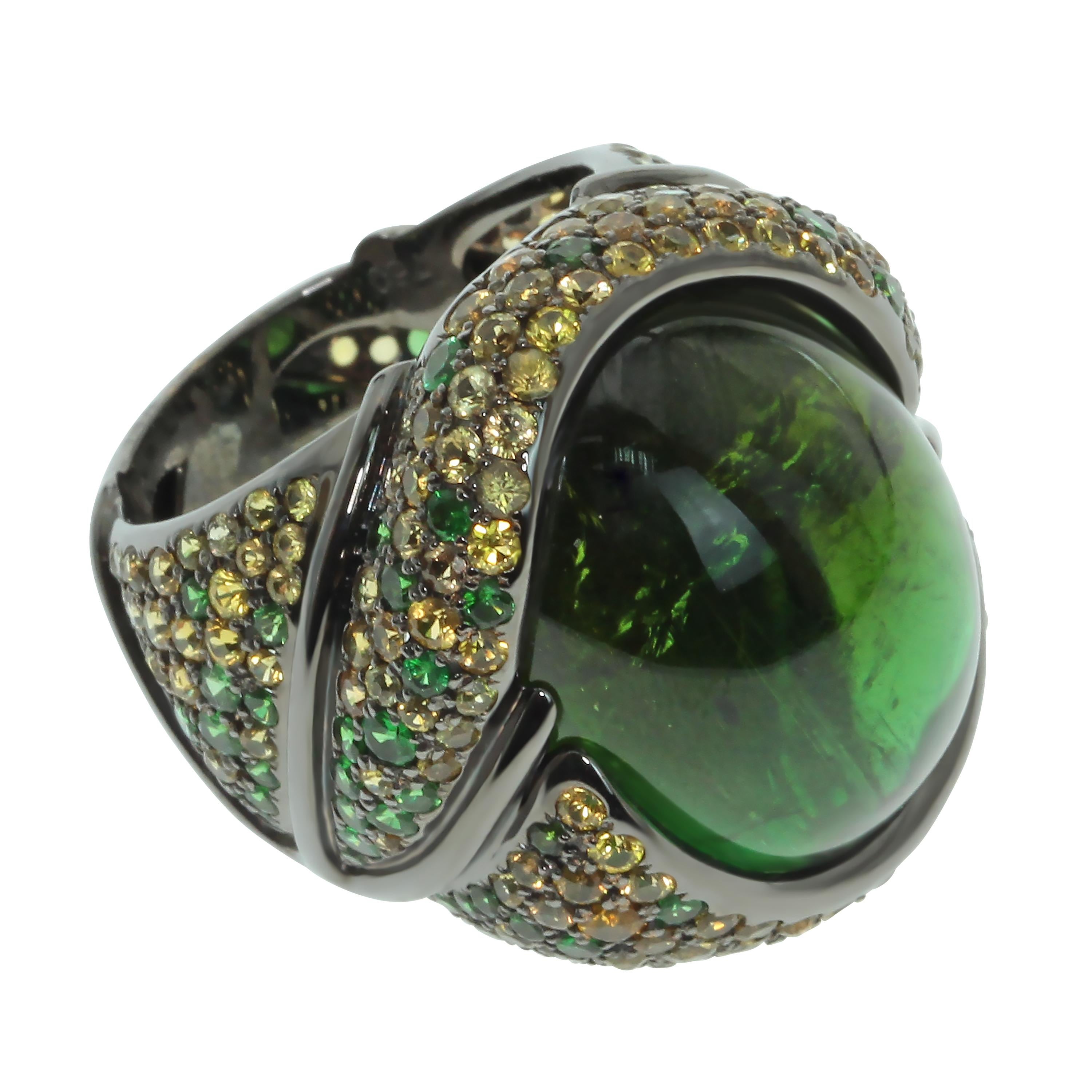 Green 23.30 Carat Tourmaline Yellow Sapphire Tsavorite 18 Karat Black Gold Ring
Absolutely spactacular Green oval Cabochon shape Tourmaline weighing 23.30 Carat surrounded by 18K Black Gold and mix of Tsavorites and Yellow Sapphires inspires