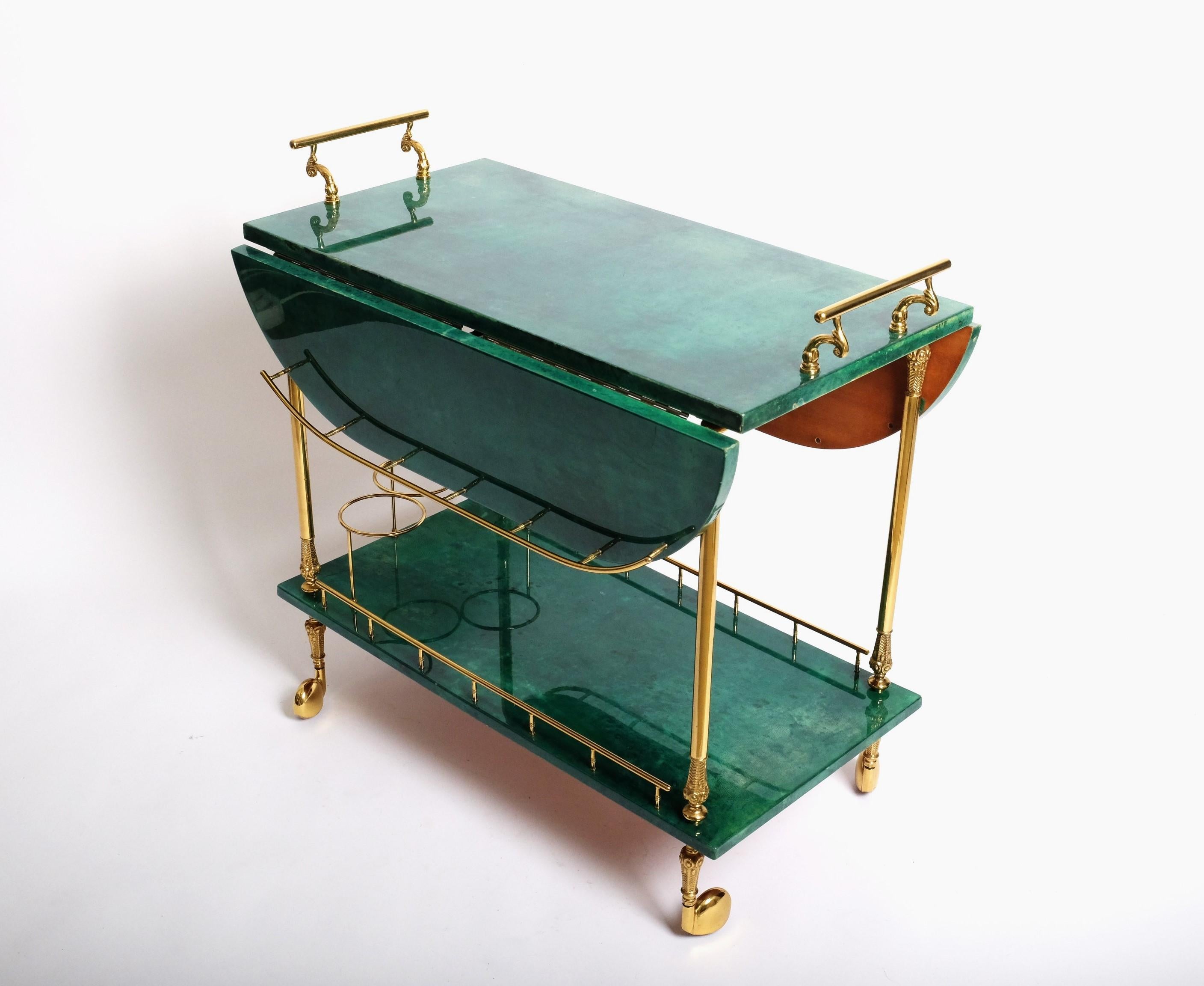 Beautiful emerald green bar cart by Italian artist and craftsman Aldo Tura, distinguished by the use of brass and lacquered goatskin that Tura was known for. The quality of Aldo Tura's craftsmanship is due to the fact that his works were only