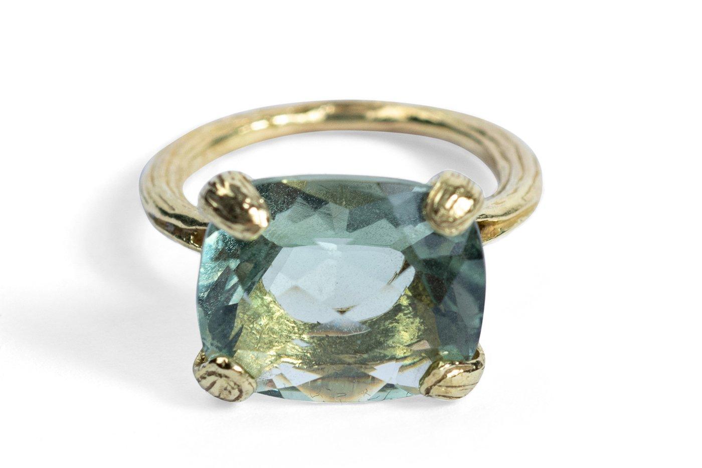 A faceted green-amethyst (also known as prasiolite) shines its soothing light, anchored in Gabrielle's 18k textured petal prong ring shank. 

Size 6
14x12x8mm faceted green amethyst rectangle and 18k textured petal prong ring shank
