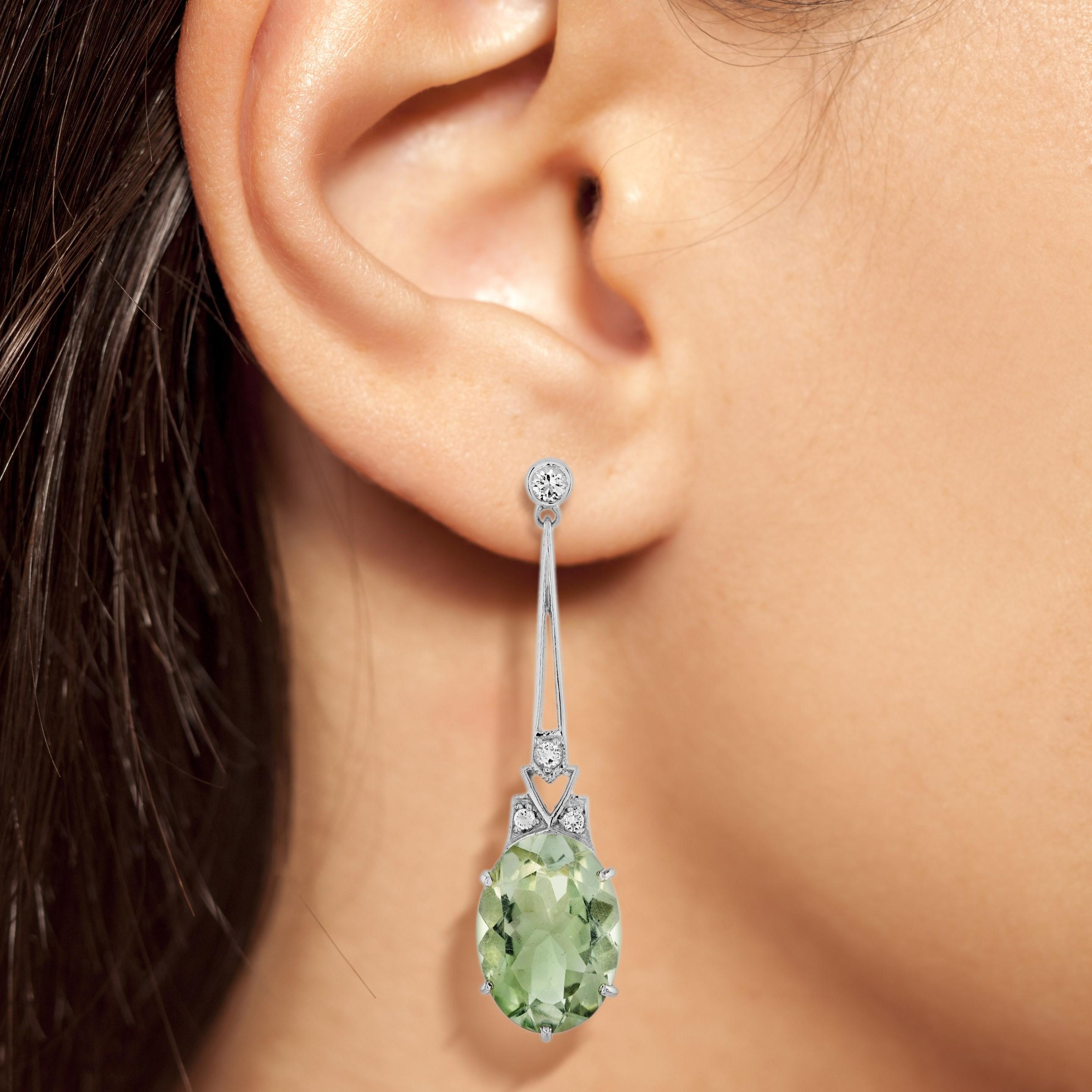 This is an exquisite pair of green amethyst drop earrings with Art Deco ear design. The earrings feature a geometric design which is set in prong with green amethysts for their centers. Each earrings are adorned with lovely sparkling diamonds set in