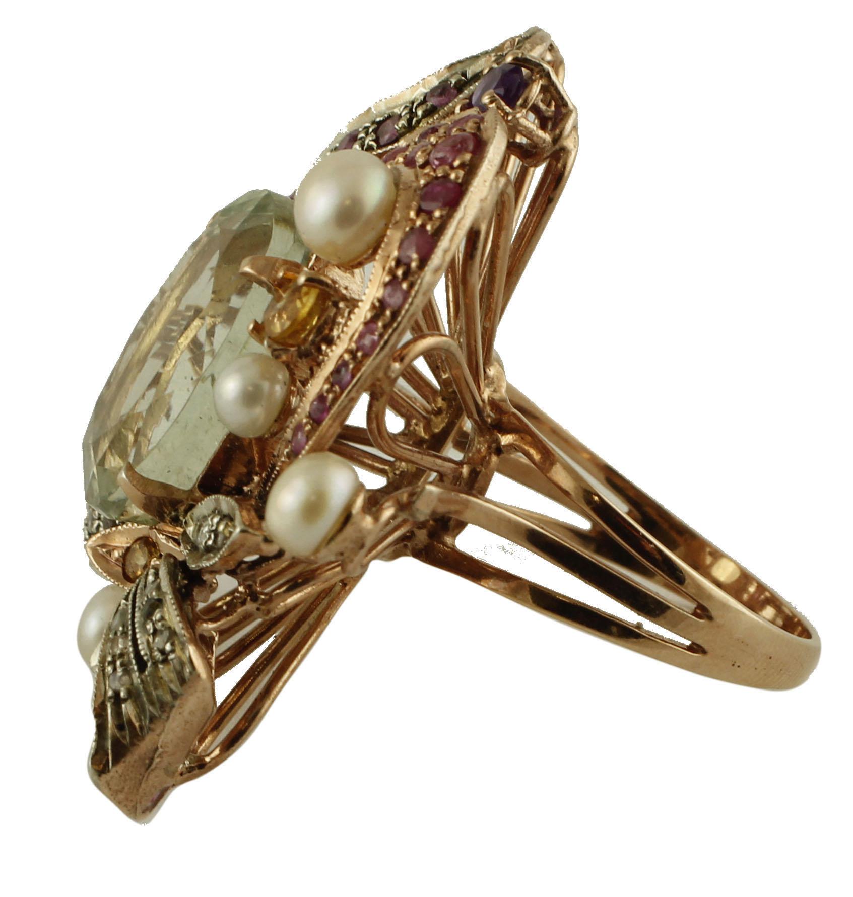 Beautiful cocktail ring in 9k rose gold and silver structure mounted with a central green amethyst surrounded by flowery details in rose gold and silver structure studded with rubies, garnet, topazes and little pearls. 
This ring is totally handmade