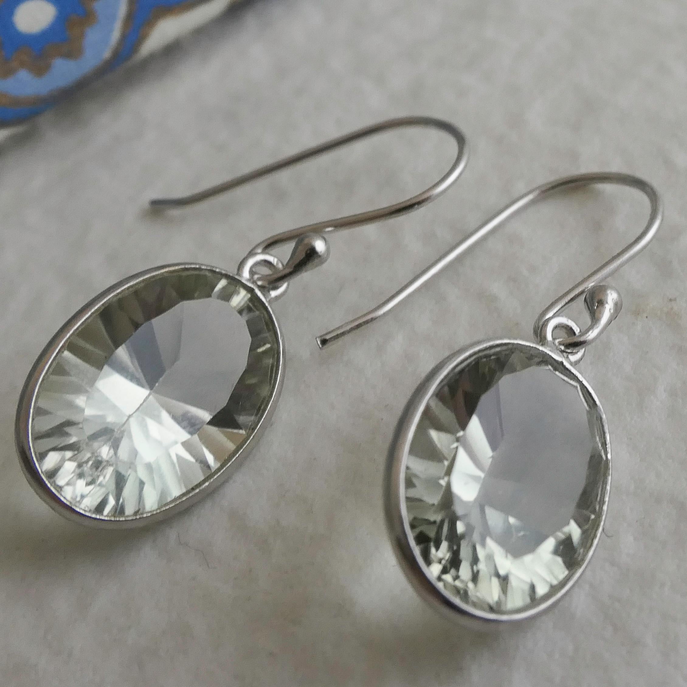 Diese eleganten Ohrringe bestehen aus 10x15 mm großen, facettierten grünen Amethysten, die fachmännisch in Sterlingsilber gefasst sind, um das sanfte, minzige Funkeln der Steine hervorzuheben. Die saubere Lünettenfassung verleiht ihm einen