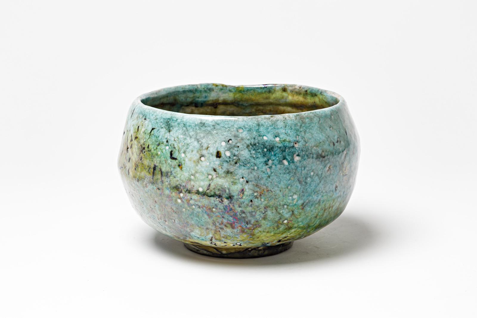 Green and blue glazed ceramic bowl with metallic highlights by Gisèle Buthod Garçon. 
Raku fired. 
Artist monogram under the base. 
Circa 1980-1990.
H : 4.3’ x 6.7’ inches.