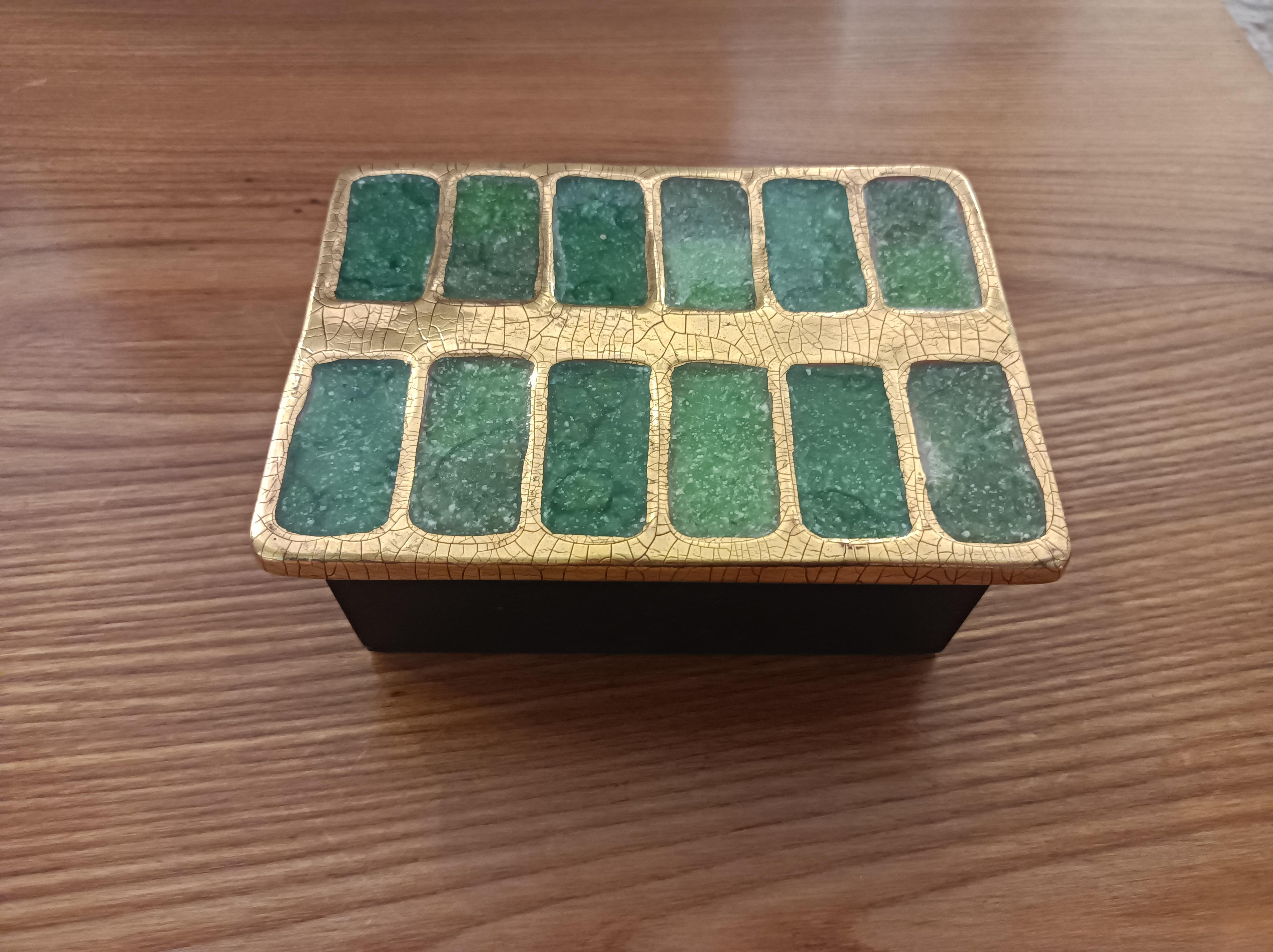 A rectangular chest embossed earthenware with crystallised green glass.
Crackled gold frame.
Wooden base with green felt at the back.
France,
Circa 1956


Dimensions : 

Height ( max) : 6 cm / 2,36 inch
Lenght : 15 / 5,90 inch
Width : 11