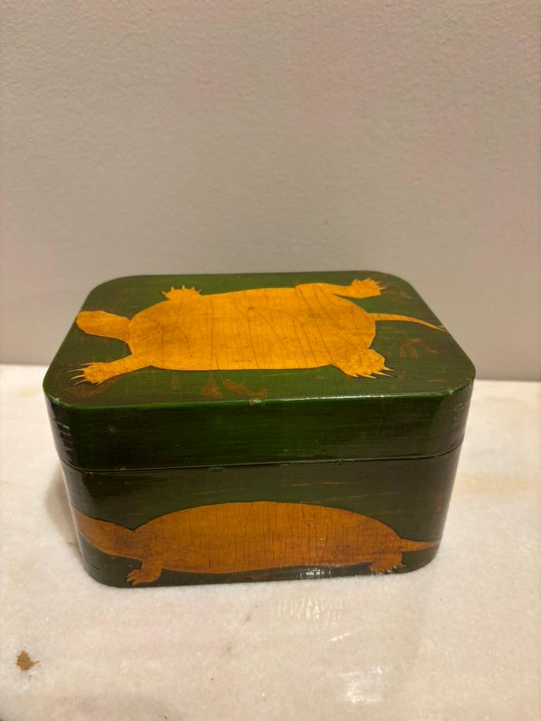 Scatola laccata verde e dorata con decorazione a decoupage di tartarughe, l'interno è foderato con carta finto guscio di tartaruga. È una scatola incantevole, il mio nuovo articolo preferito. La parte superiore, quella anteriore, quella posteriore e