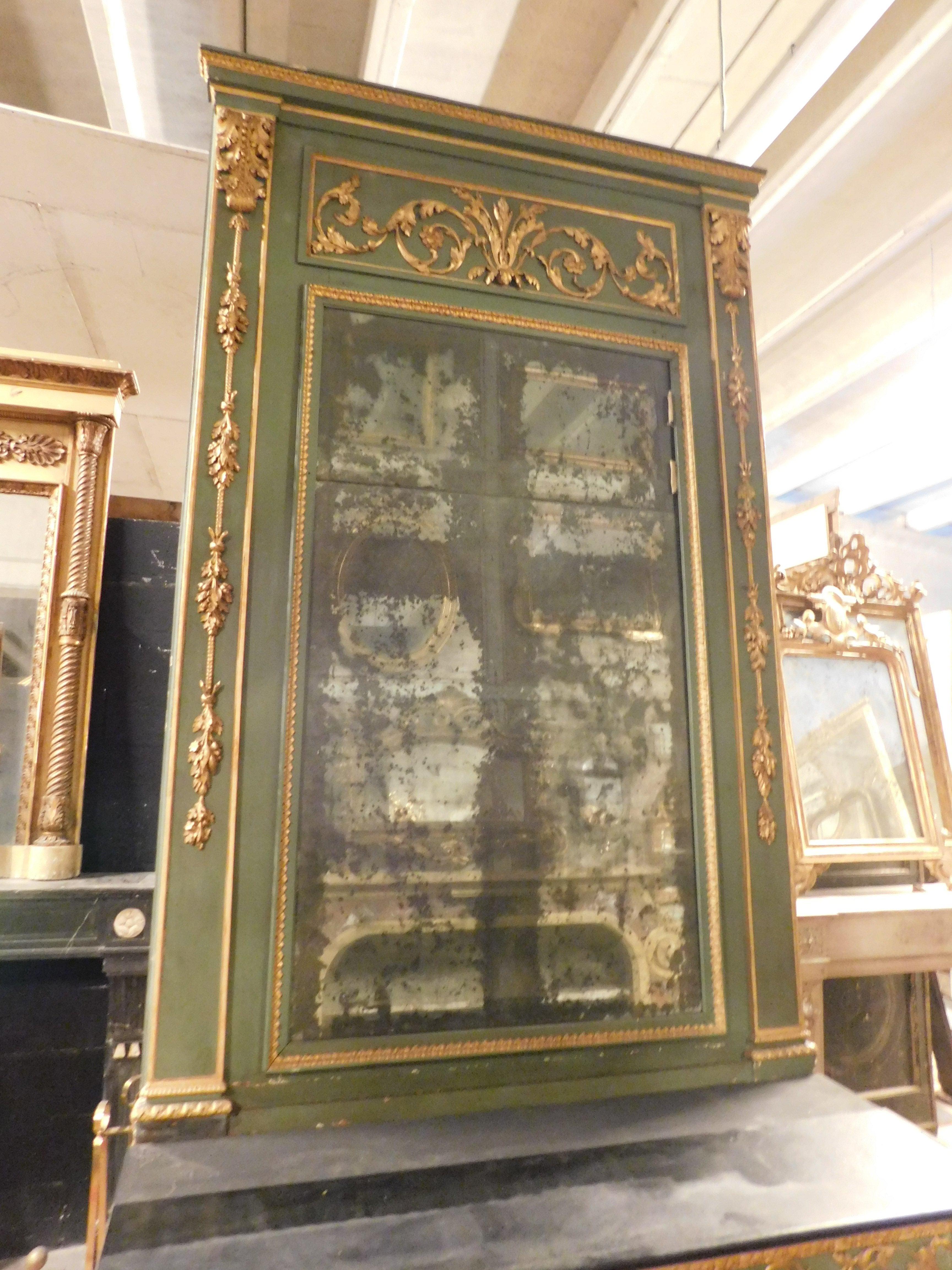 Consolle antica laccata verde completa di specchio e tavolo, intagliata con decorazioni dorate, originale del XVIII secolo, proveniente dalla Francia. Il piano è stato restaurato e laccato in nero, le gambe sono scanalate. Le dimensioni massime