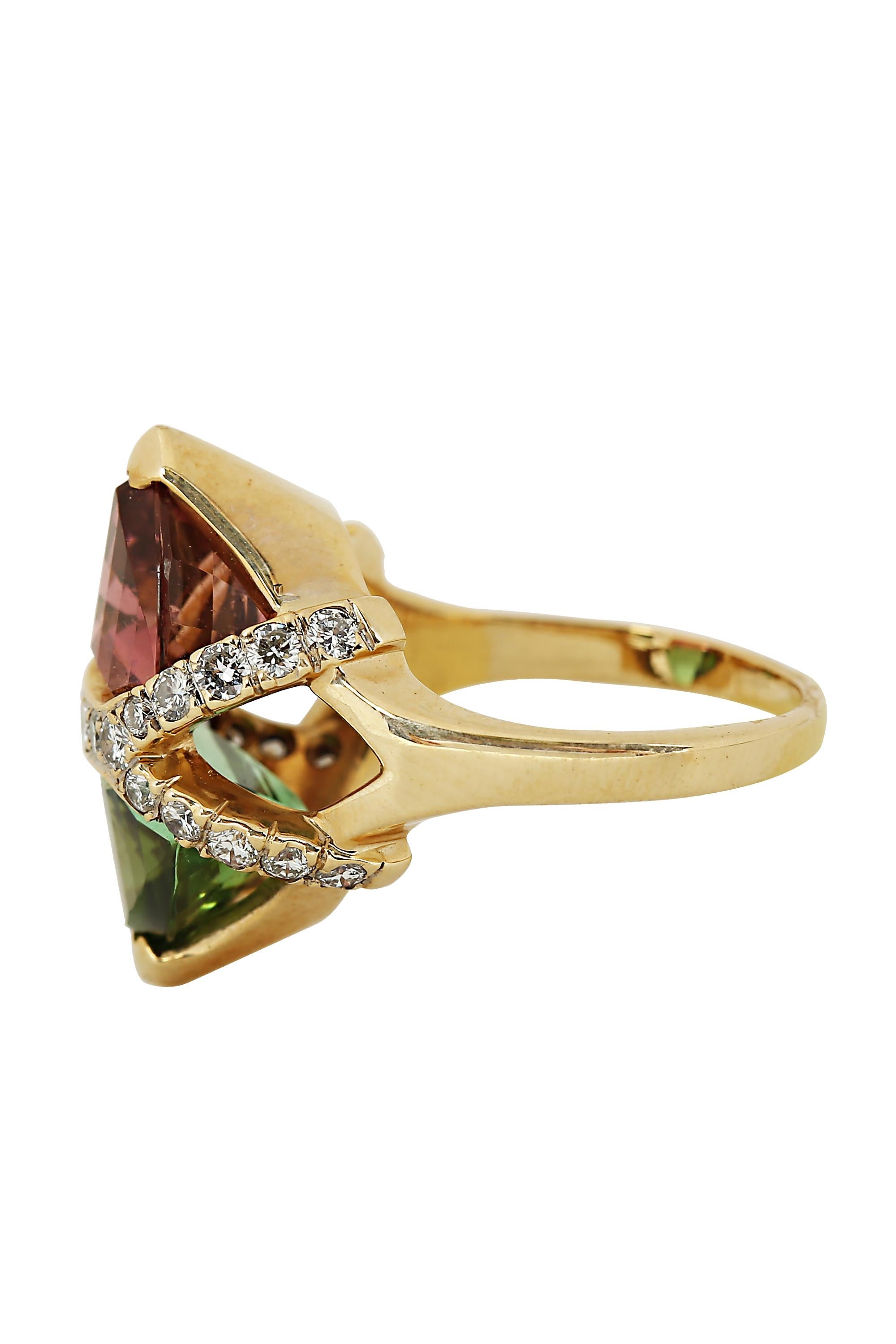 This striking ring features the winning color combination of pink and green tourmalines bisected by a bright row of diamonds terminating in twin chevrons. Crafted in 14 karat yellow gold with approximately 10 carats of shield shaped tourmalines and