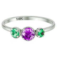 Bague en or 14k sertie de pierres précieuses vertes et violettes.