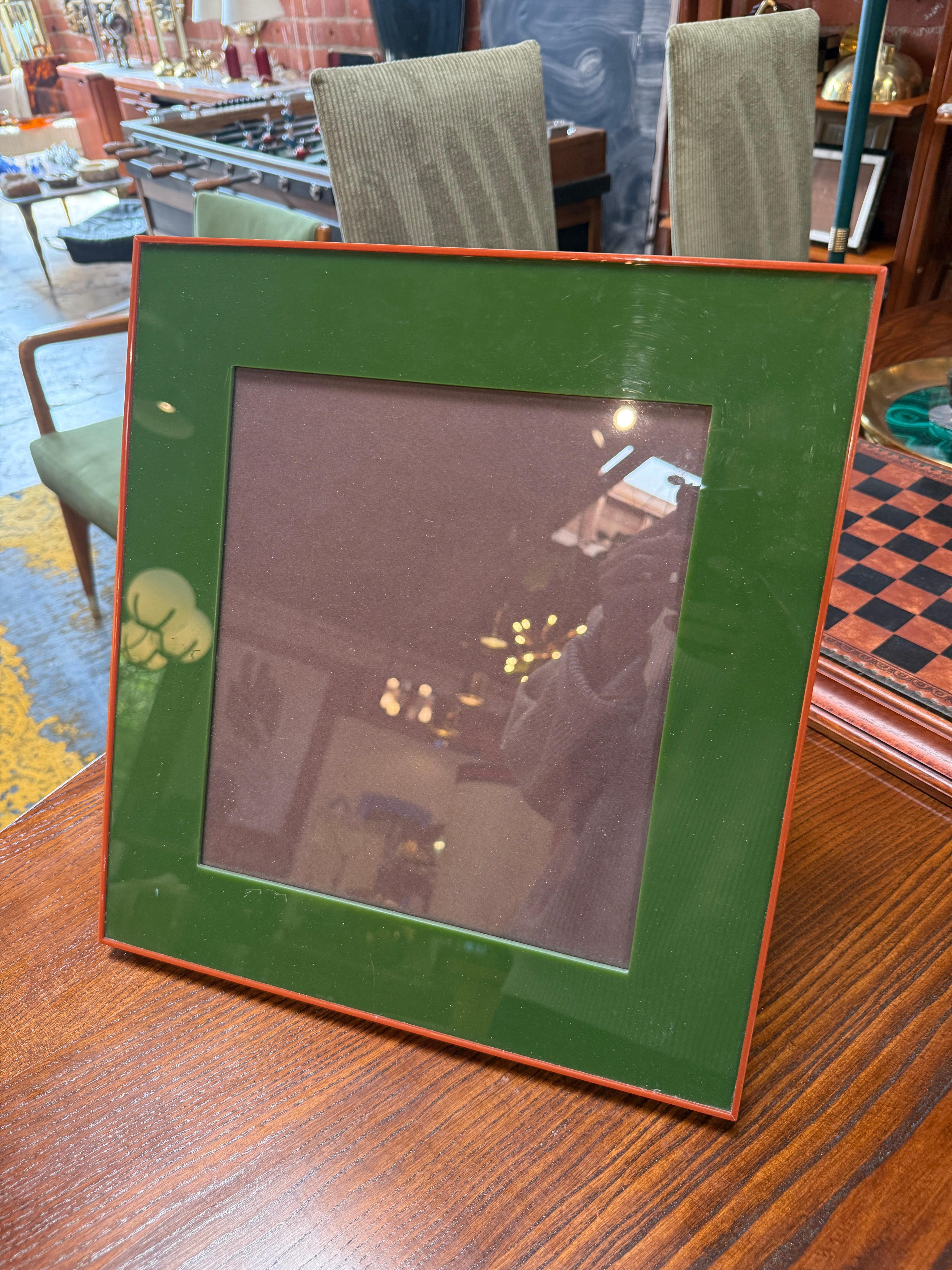 Ce cadre photo carré en émail vert et rouge offre une esthétique audacieuse et moderne avec une touche de luxe raffiné. Le cadre présente une face émaillée d'un vert profond et brillant, bordée d'un bord rouge contrastant, créant une association de