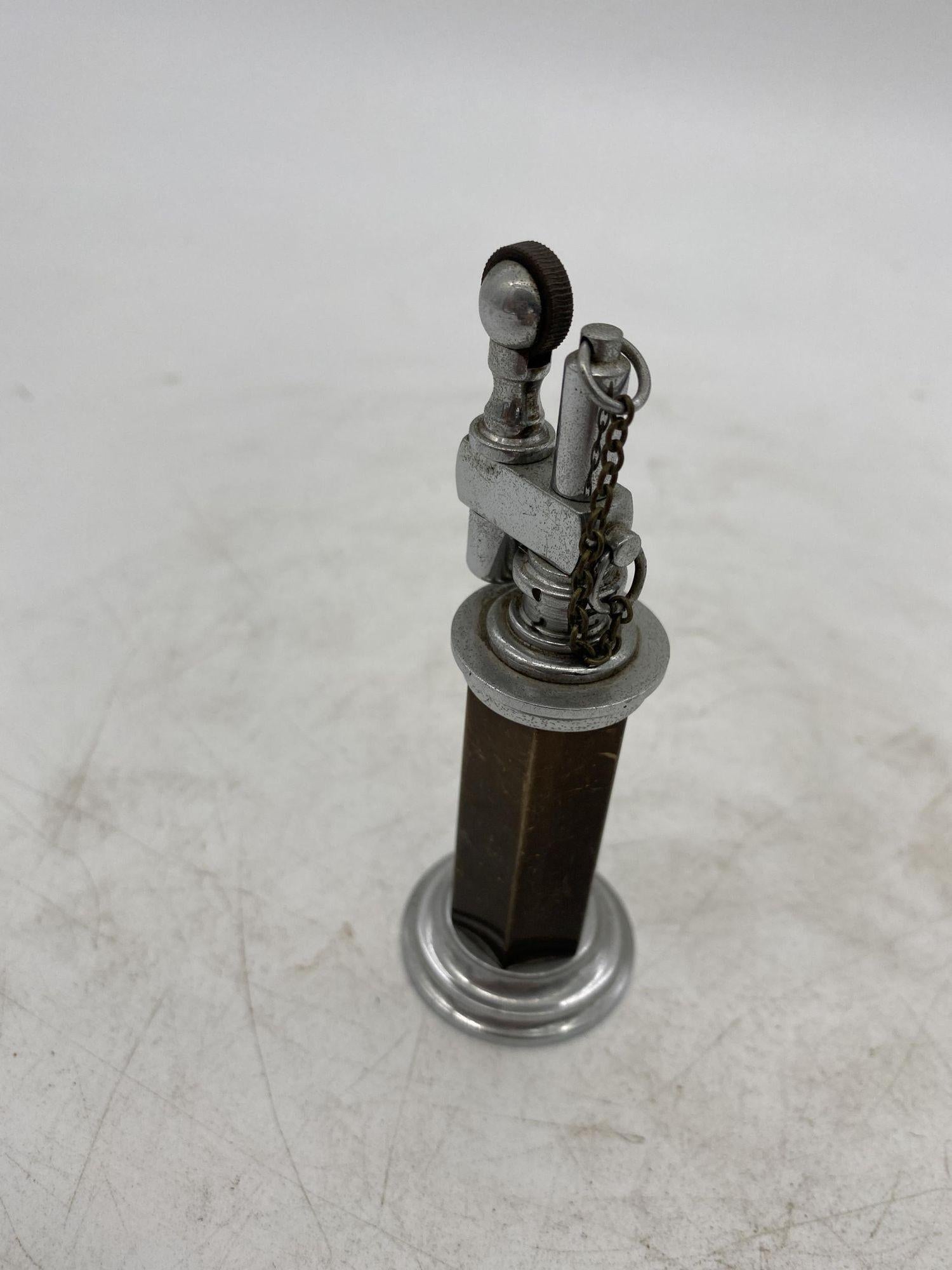 Green and silver column table petrol lighter with chain cap by Daltis New York City.

Measures: 5.5