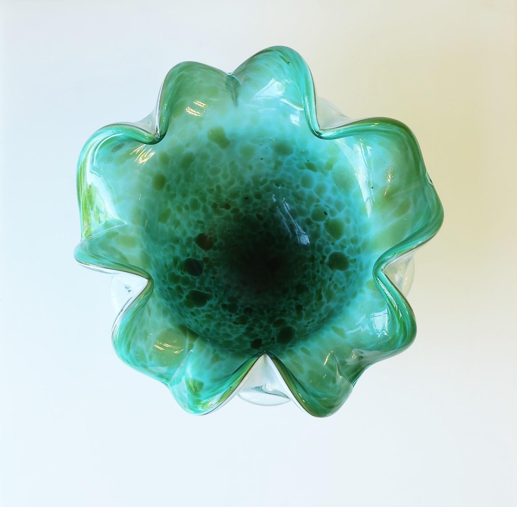 A very beautiful and substantial green and white Italian Murano art glass bowl, in the Organic Modern style, circa mid-20th century, 1960s, Italy. Glass hues include both Kelly green and Emerald green hues with a white exterior. Piece has a modern