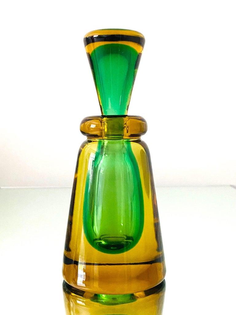 Mid-Century Modern decorative bottle with tapered stopper by Flavio Poli for Seguso. Beautifully handcrafted in vibrant hues of emerald green and golden yellow. Handblown featuring Sommerso technique whereby the green glass is submerged into yellow