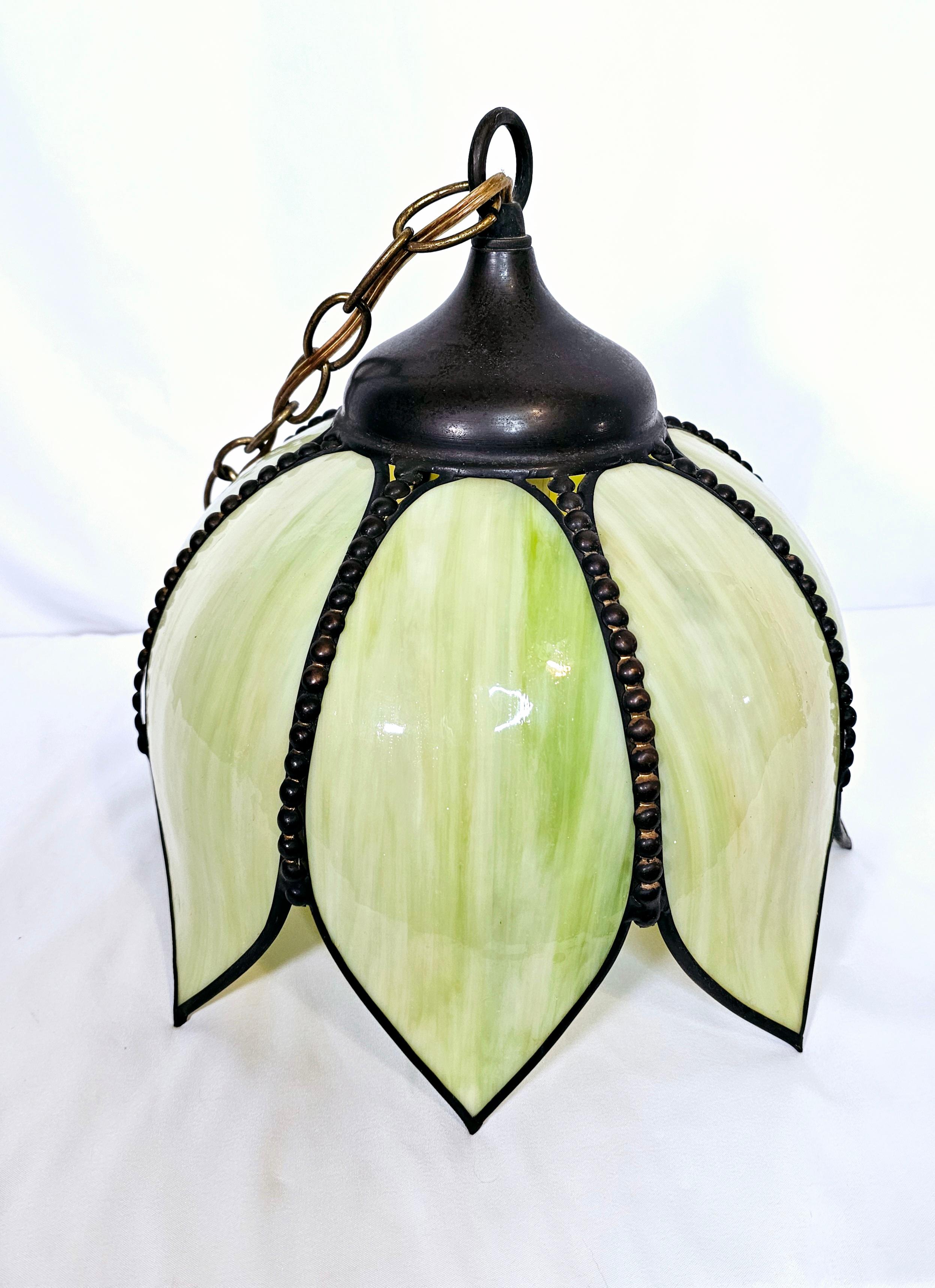 Beautiful yellow green slag glass tulip pendant light. Art Nouveau style Brass hardware and trim. Original chain is about 10' long.

Vintage art nouveau style, yellow green slag glass tulip pendant light. Comprised of 8 slag glass petals and black