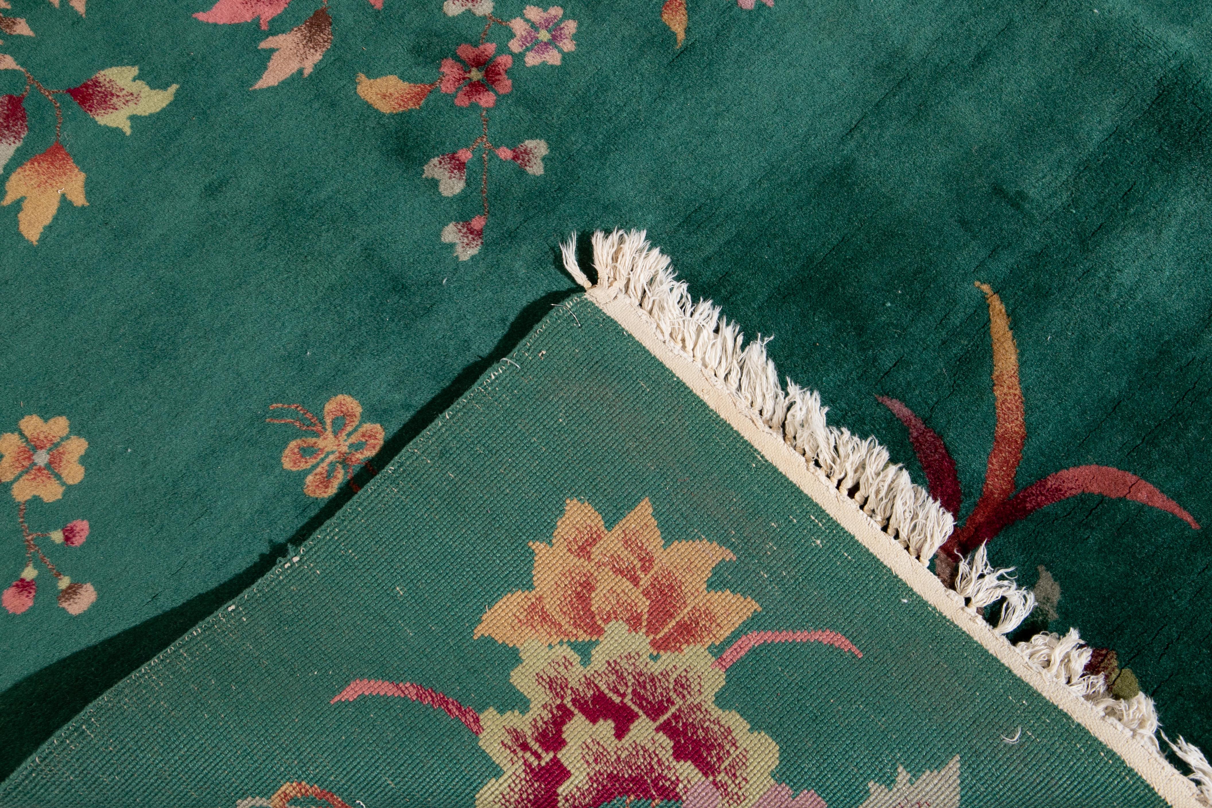 Beautiful antique Chinese Art Deco rug, a hand knotted wool rug with a green field, and multi-color accents in a Gorgeous all-over Classic Chinese floral design, circa 1920.

This rug measures 8' 10