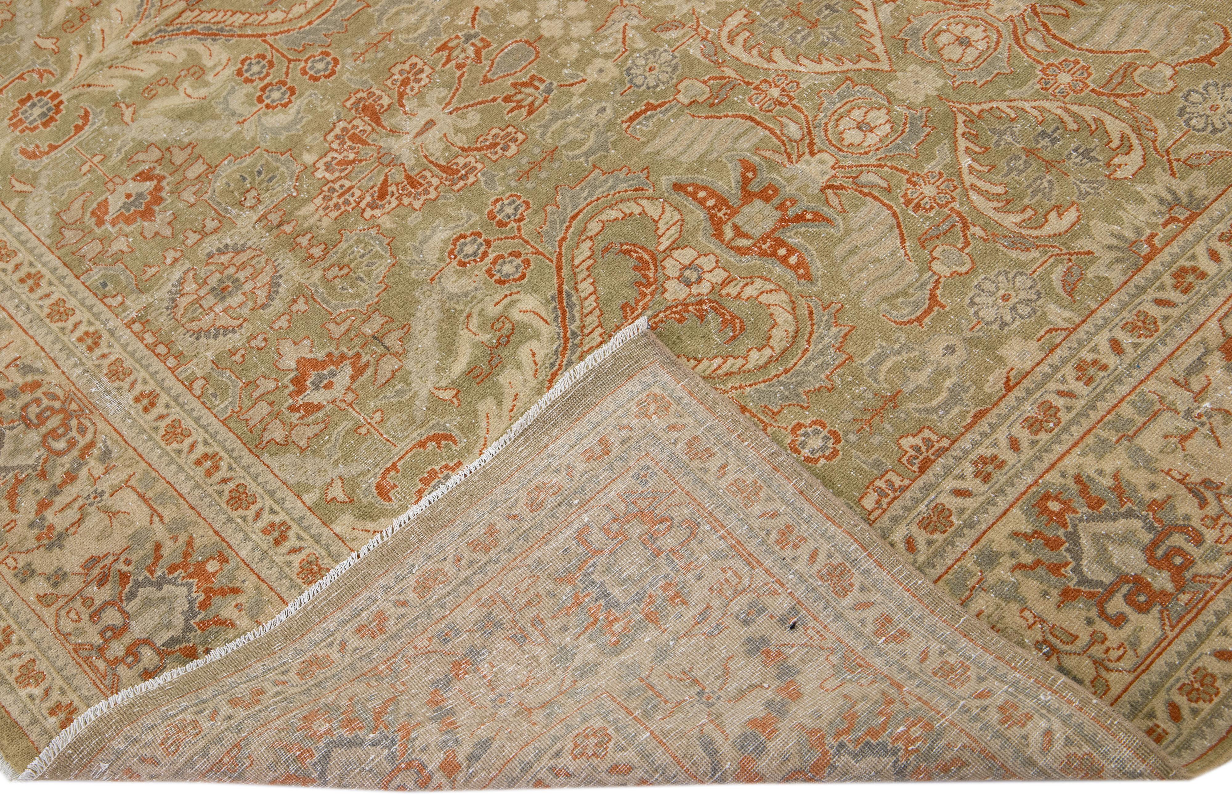 Beautiful Antique Mahal hand-knotted wool rug with a green color field. This Persian rug has orange, beige, and gray accents in an all-over floral design.

This rug measures 7' x 7'.
