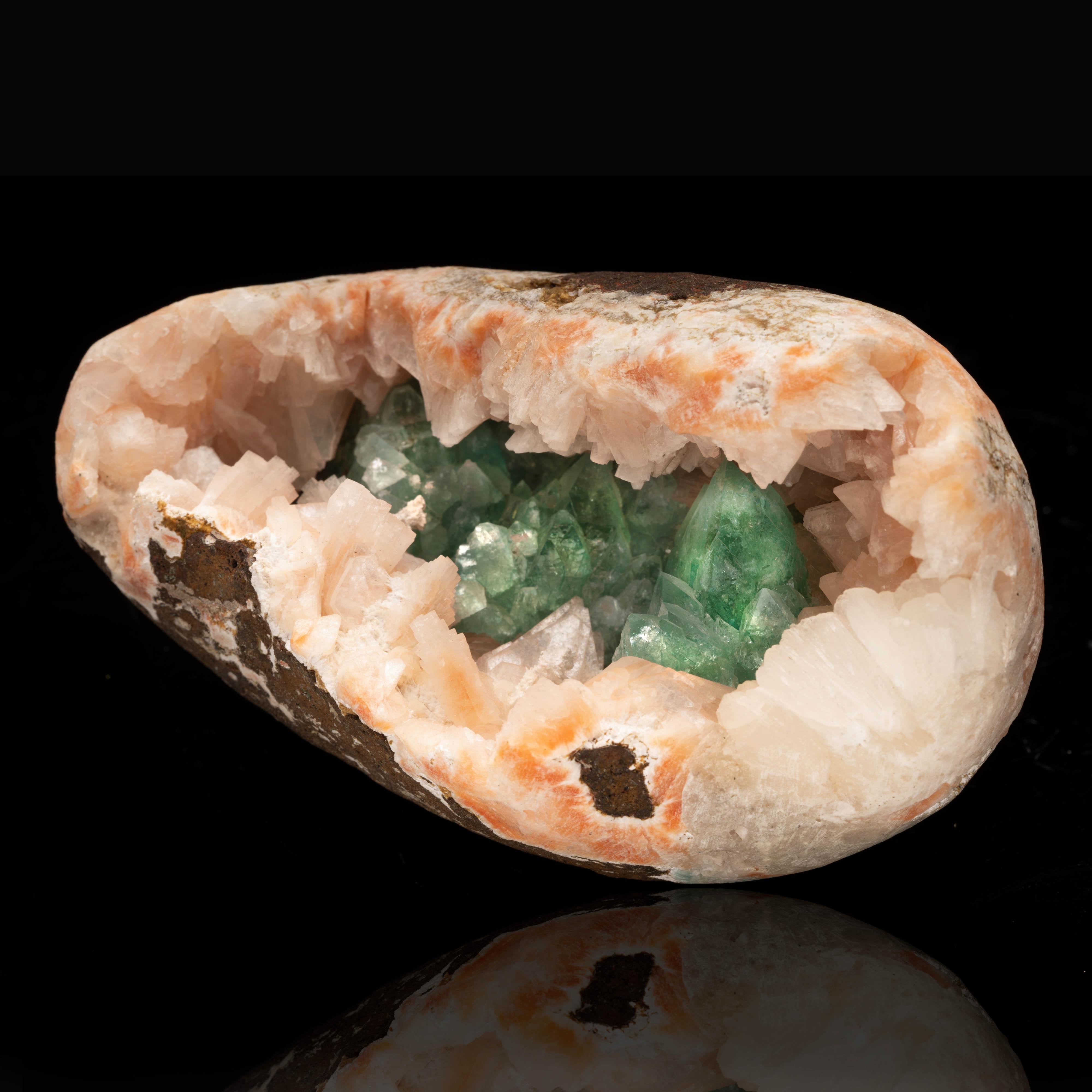 This unique combination specimen is a vug or natural crystal-lined cavity formed from peach stilbite, which has crystallized in gemmy points over the surface of its hollow interior. For further interest, this vug is stuffed with impossibly deeply