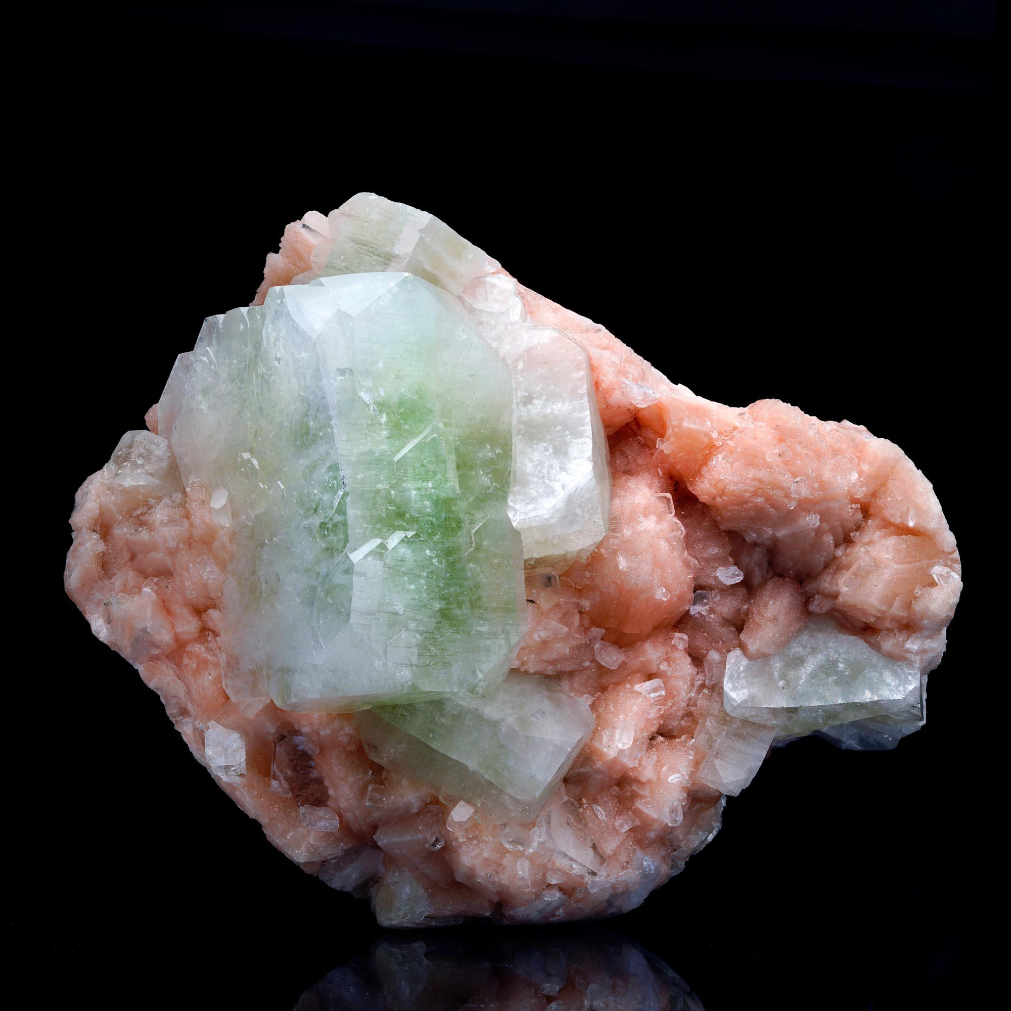 Questo pezzo grande e strutturato presenta enormi cristalli di apofillite verde, gemmati e splendidamente formati, che crescono su un'abbondanza di stilbite color pesca, lucida e splendidamente pigmentata. Questo esemplare di grandi dimensioni