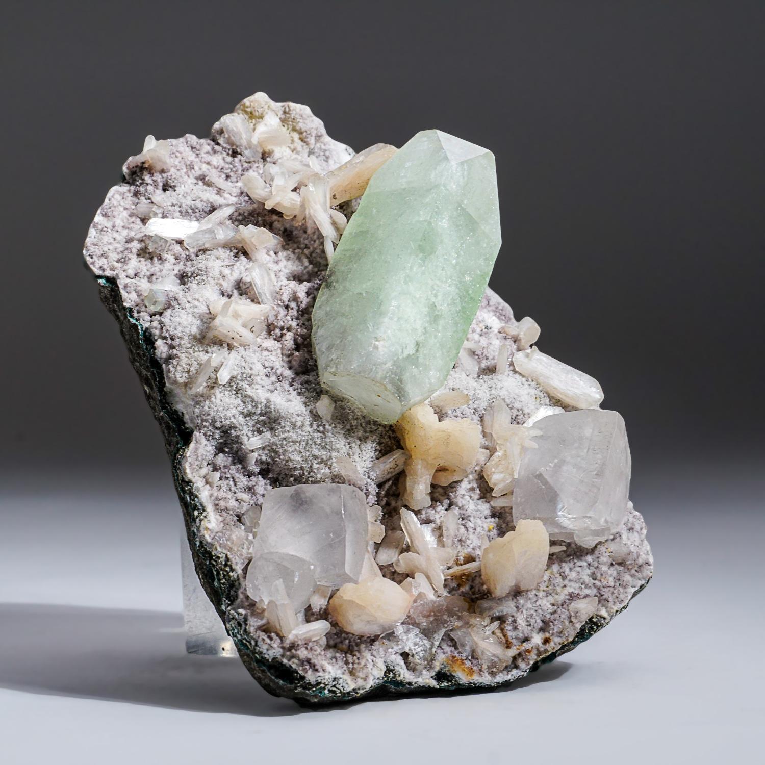 From Nasik District, Maharashtra, India Large translucent to transparent apophyllite crystal cluster with twinned crystals of calcite on matrix with bladed translucent pale-pink stilbite crystals. The apophylite has rich gemmy green color This