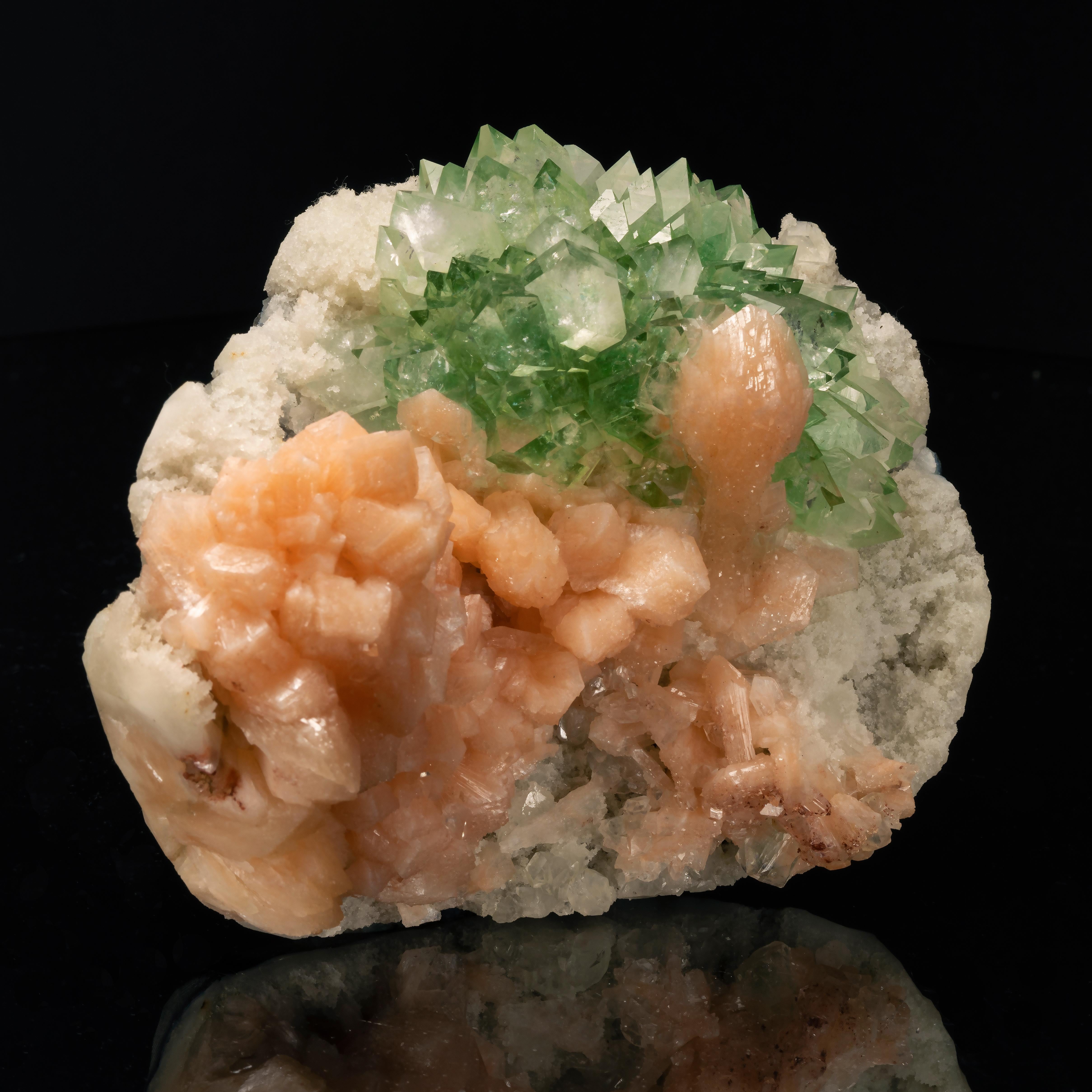 This show-stopping specimen displays a stunning, deep colored perfectly translucent green apophyllite crystals with flawlessly terminated tips, accented by a lushly peach-hued stilbite crystals that is balance the left-hand side of the matrix and