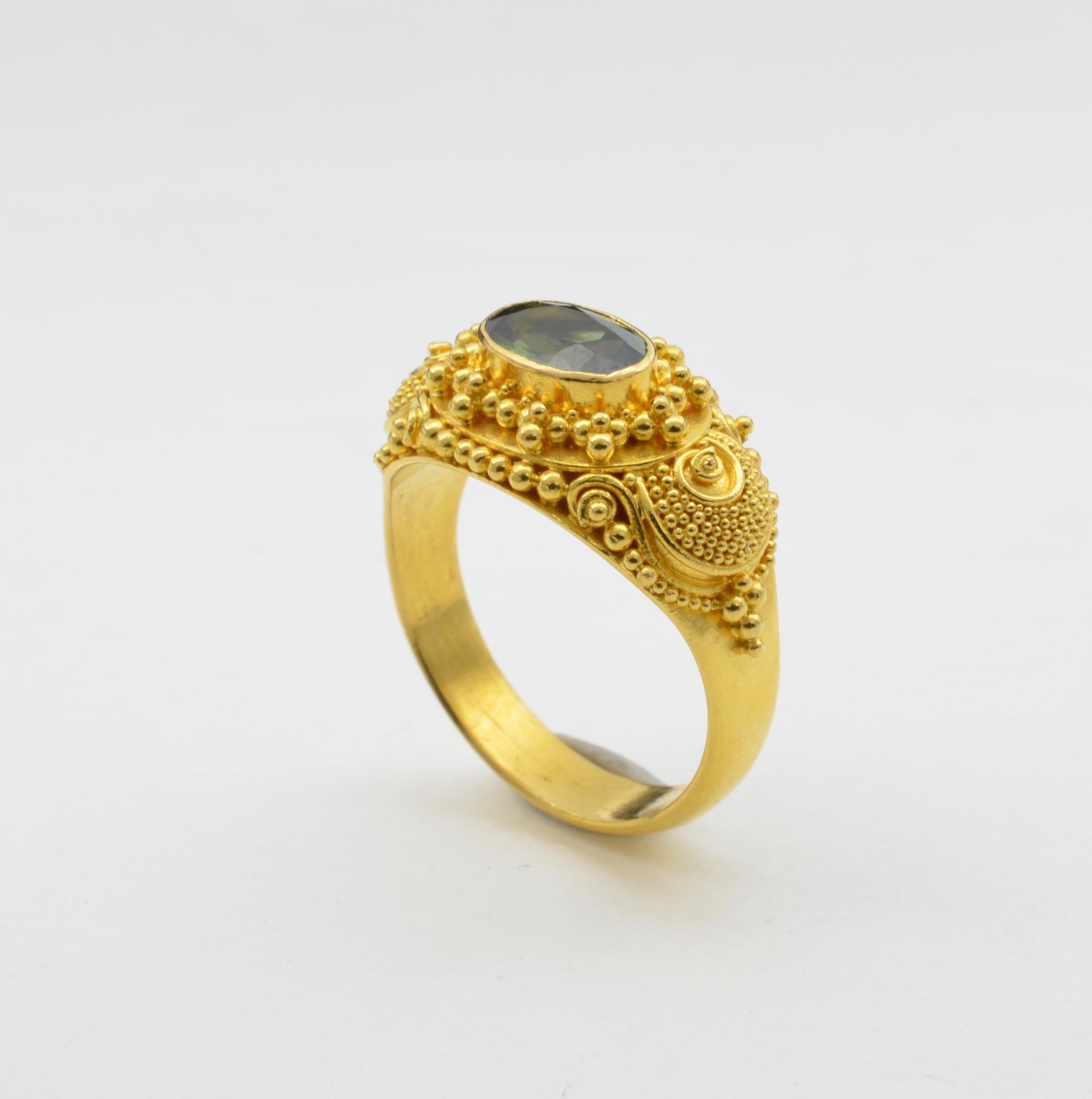 Intricate detail and spirals swirl around this deep green faceted tourmaline ring. Set in high carat 22K yellow gold this ring makes a statement fit for the Maharaja. Royal, regal and bright, the yellow gold glows in classical Indian fashion with
