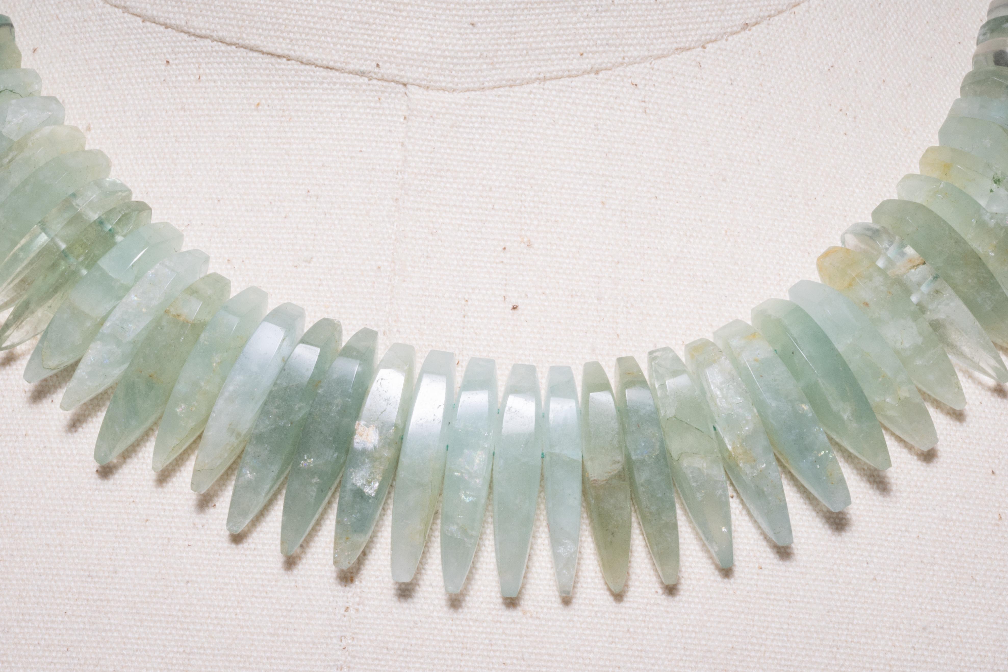 A lovely green aquamarine, a stone in the beryl family, in a very unusual bead shape and color.  Dimensional spears nest together to create this flat, close-fitting beaded necklace.  The stones are slightly graduated and the colors run to shades of