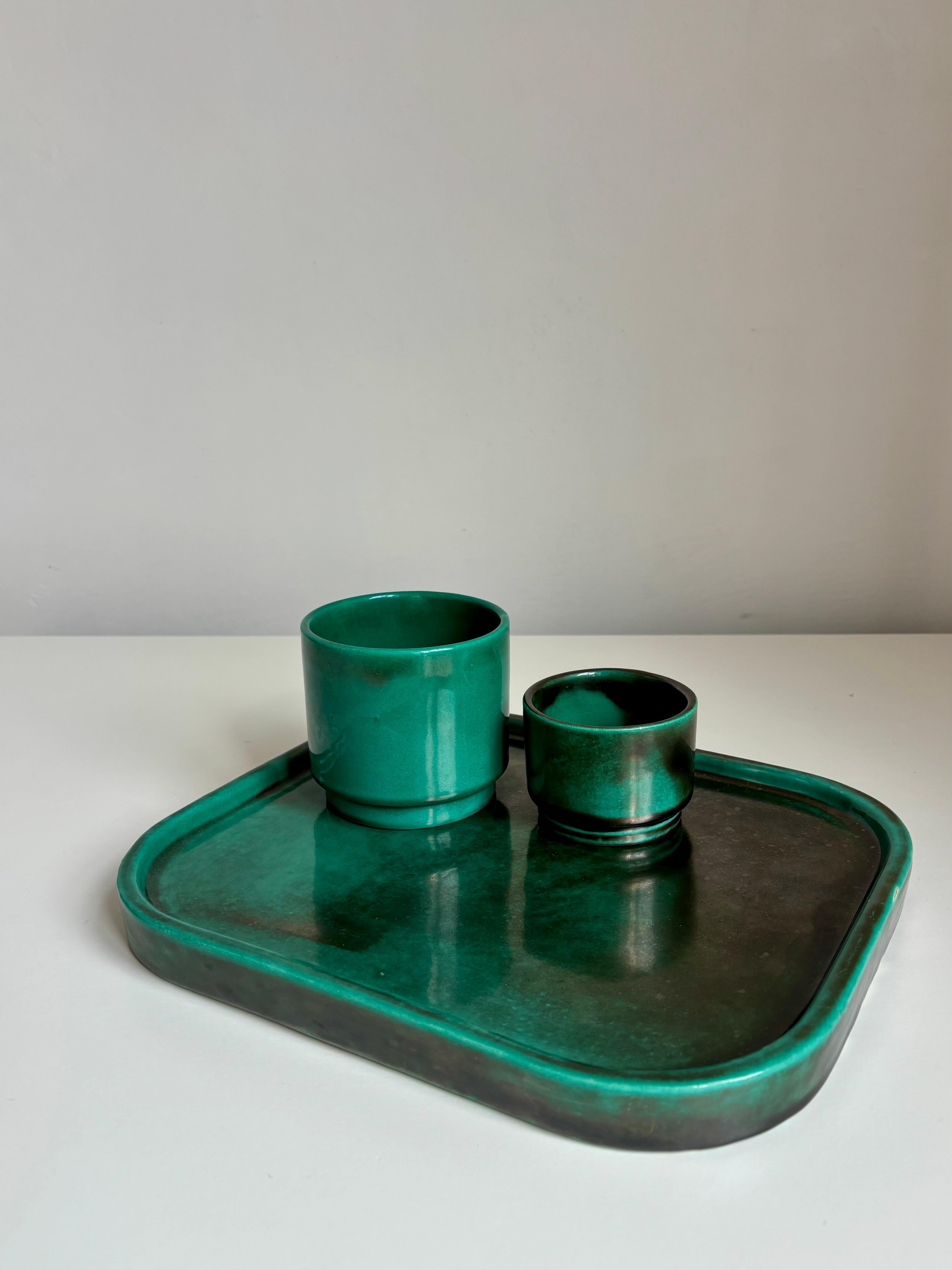 Impresionante, elegante y sencillo juego de vajilla Art Decó de inspiración japonesa en brillante esmalte verde esmeralda y negro. Producido en el estudio Upsala Ekeby atribuido a Harald Östergren, años 30. Este elegante conjunto consta de una