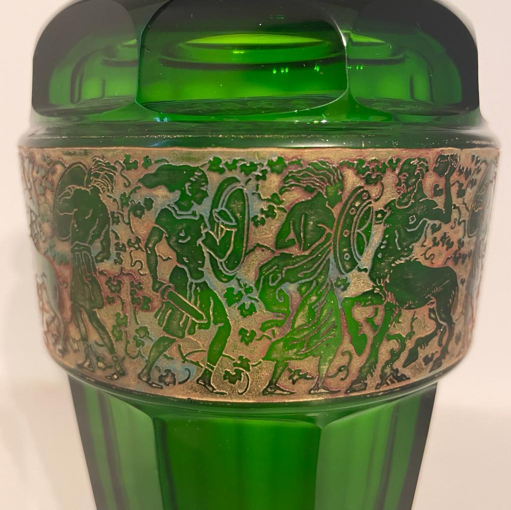 This green Art Deco frieze glass vase by Moser Karlsbad is a symphony of art and design. The vase's geometric frieze dances across its surface, creating a mesmerizing effect. The rich green color adds a touch of elegance, while the high-quality