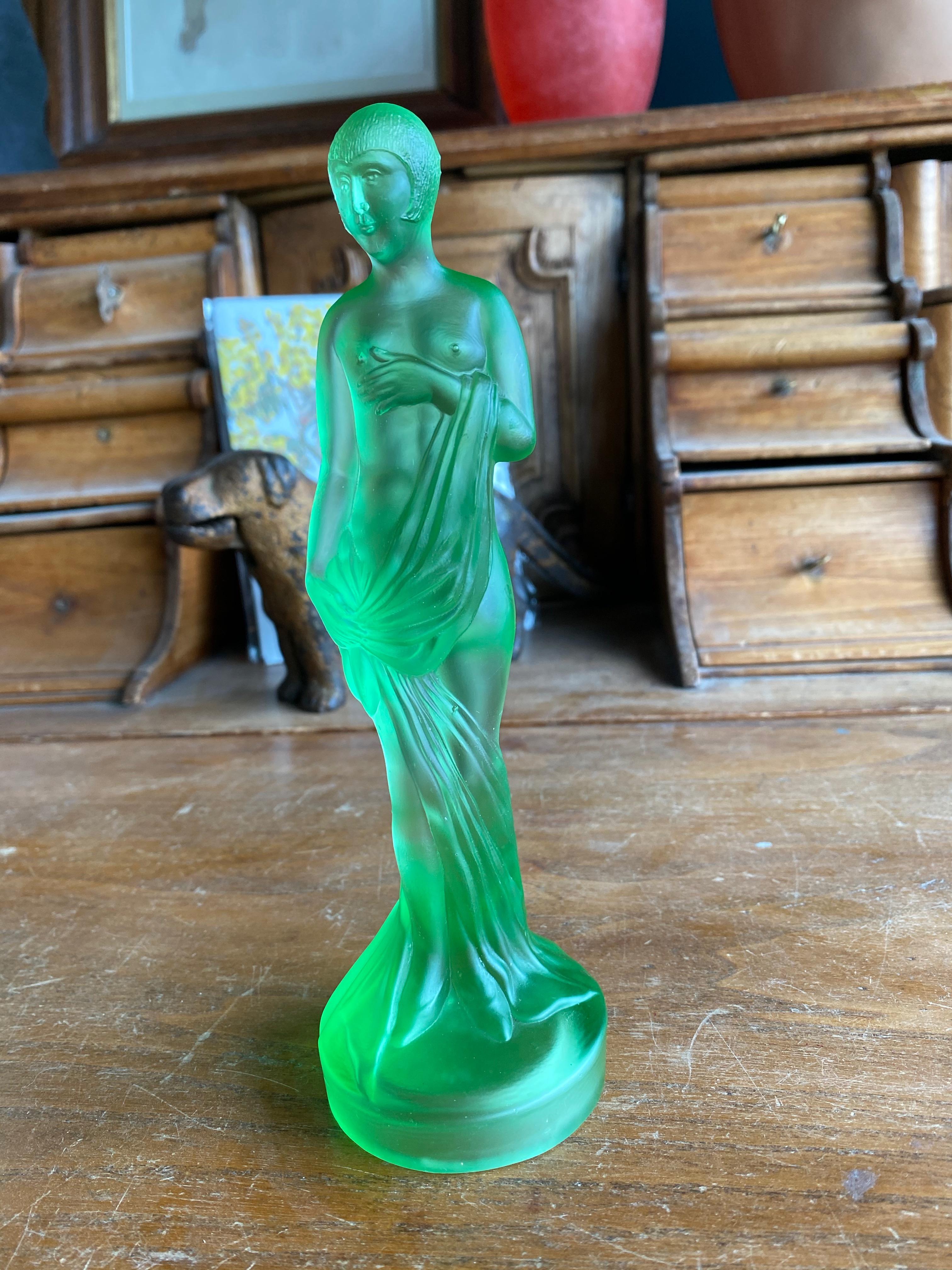 Decorative glass figurine of a 1920s lady. The figure is made of green satin pressed glass and looks good on any shelf, windowsill or even as a table decoration.

The foot is slightly bumped (see photo).