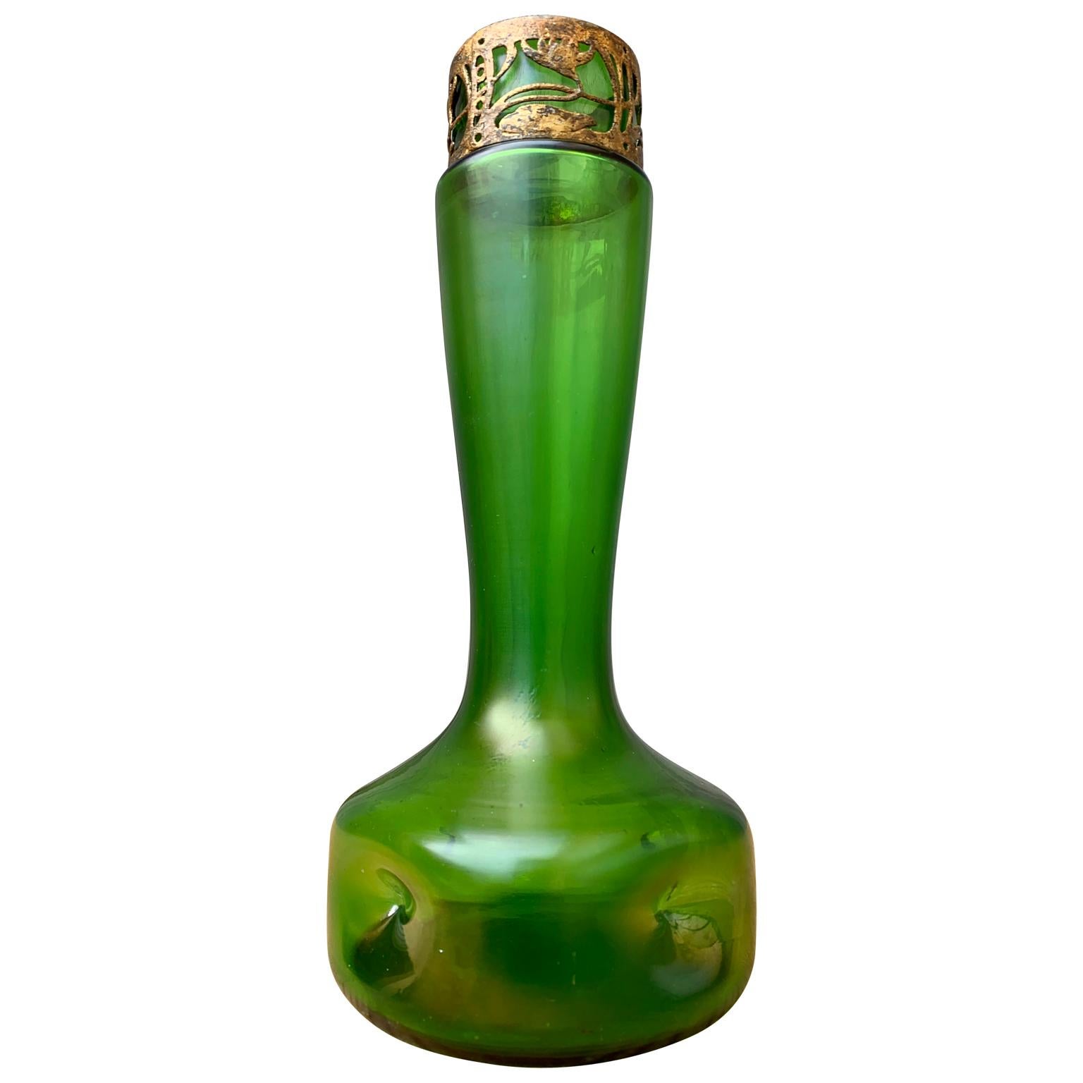 An early 19th century green glass Art Nouveau vase with gilded and flower decorated metal finial.