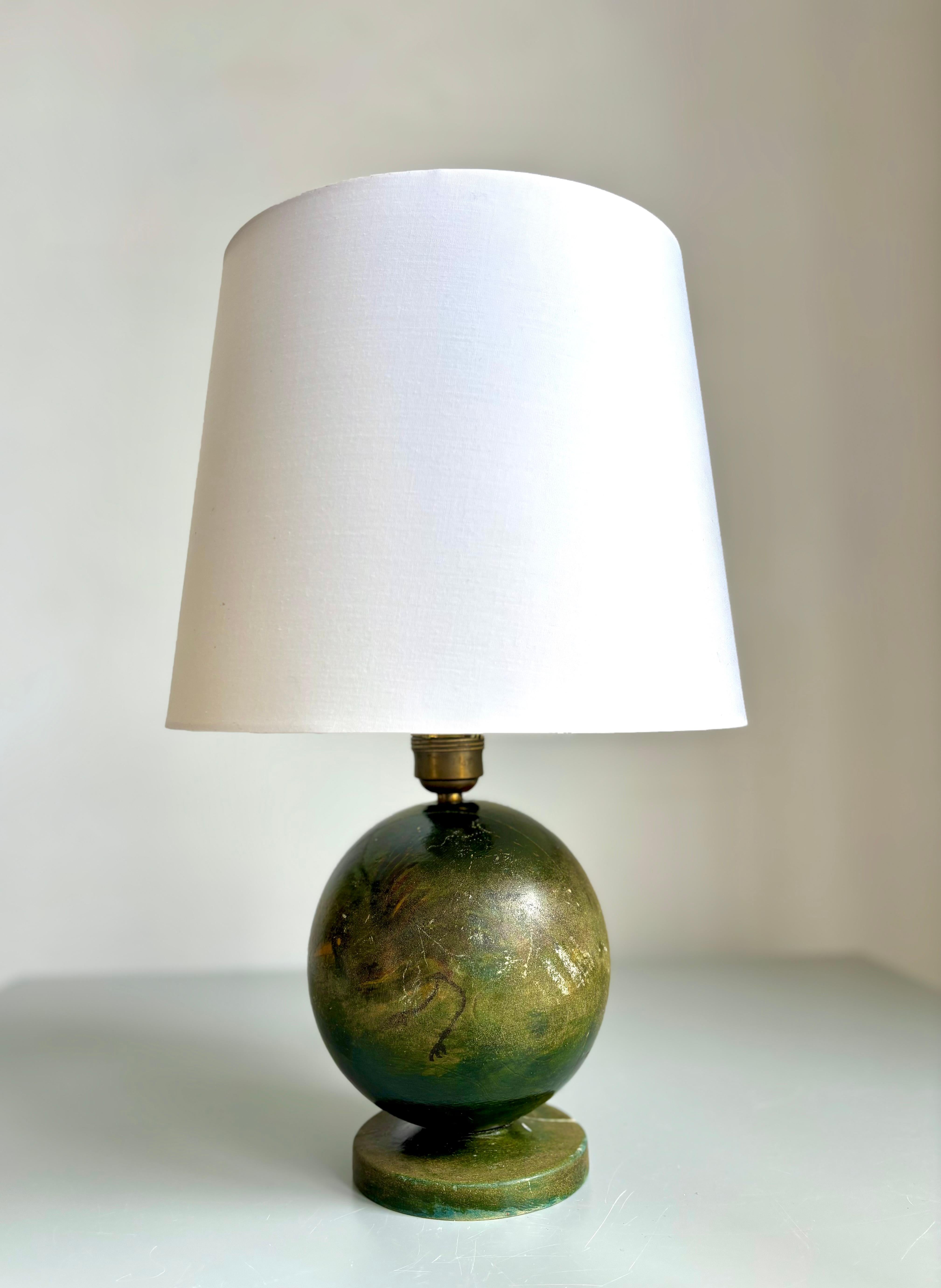 Antigua lámpara de sobremesa esférica de madera bellamente lacada en color verde oscuro terroso con dos pájaros multicolores pintados a mano, uno a cada lado. Creado por un diseñador anónimo en los años 1910-1920. Grifería original de latón y