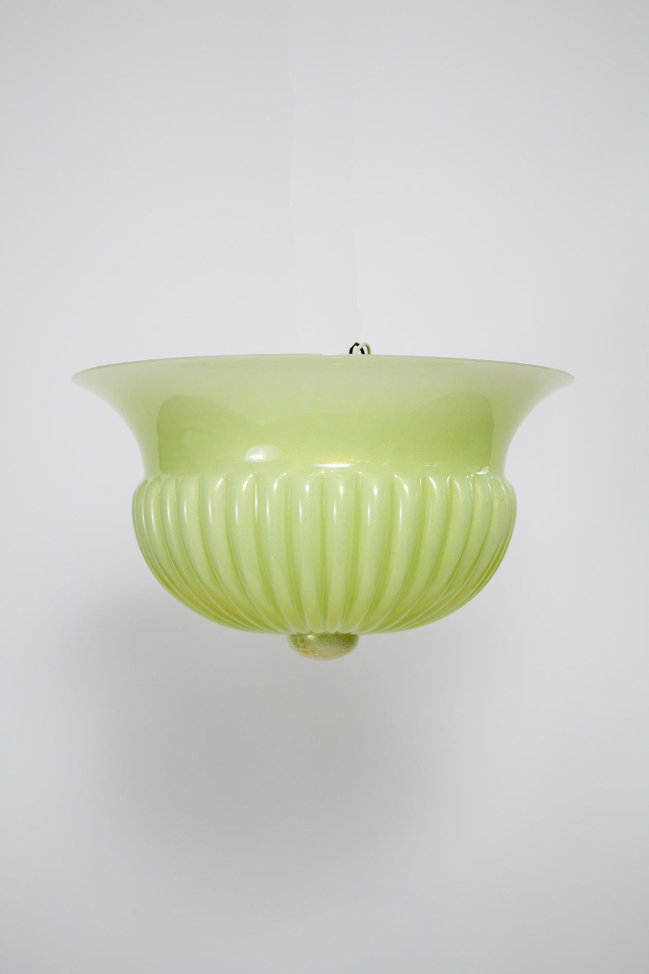 This is a beautiful piece of Barovier & Toso glass. It is a creamy light green color with gold flecks concentrated around the center and throughout the glass. Fluted edge, smooth and the top with ribbing at the bottom, and comes together with a