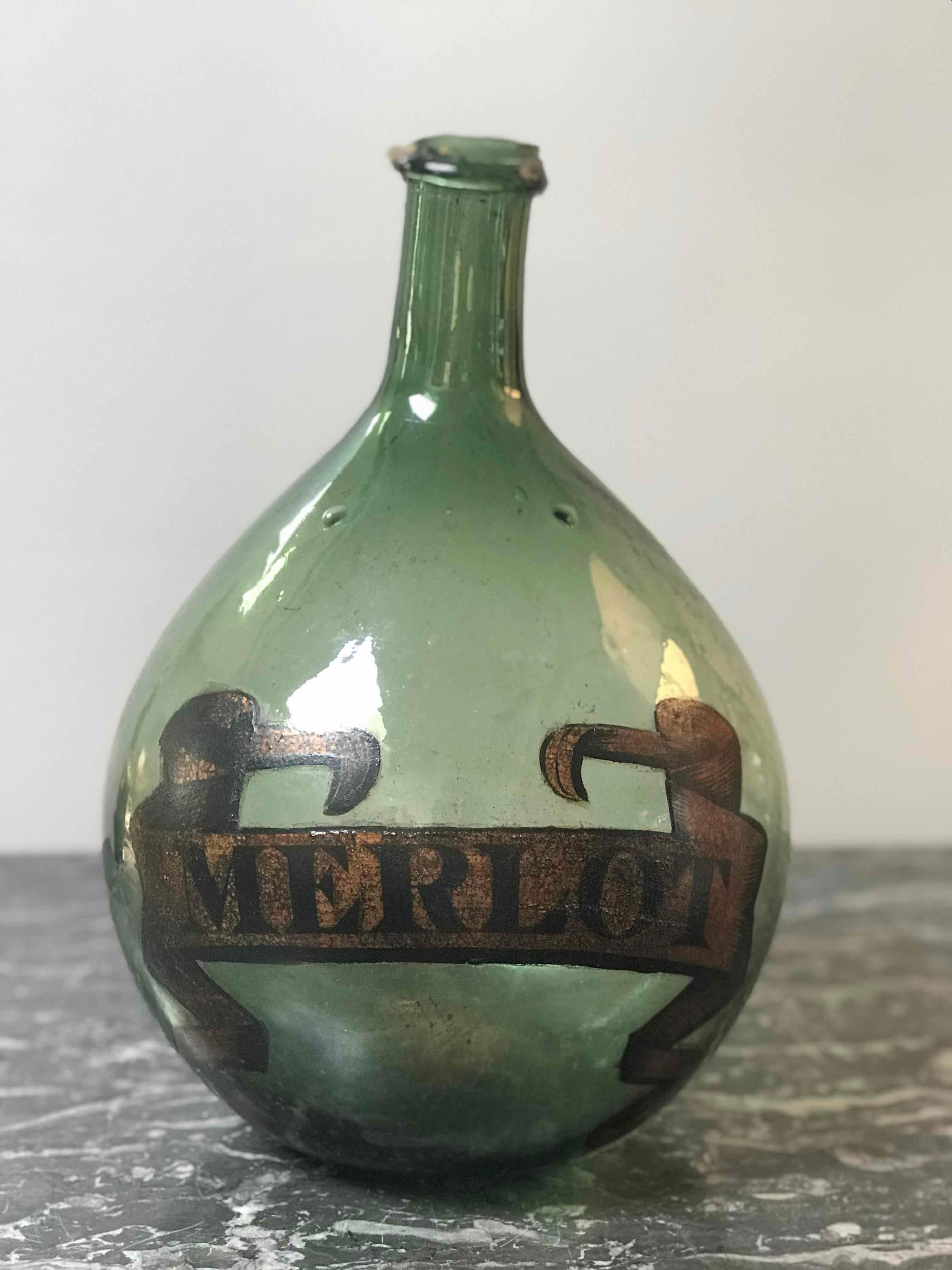 A green blown bottle with merlot label.