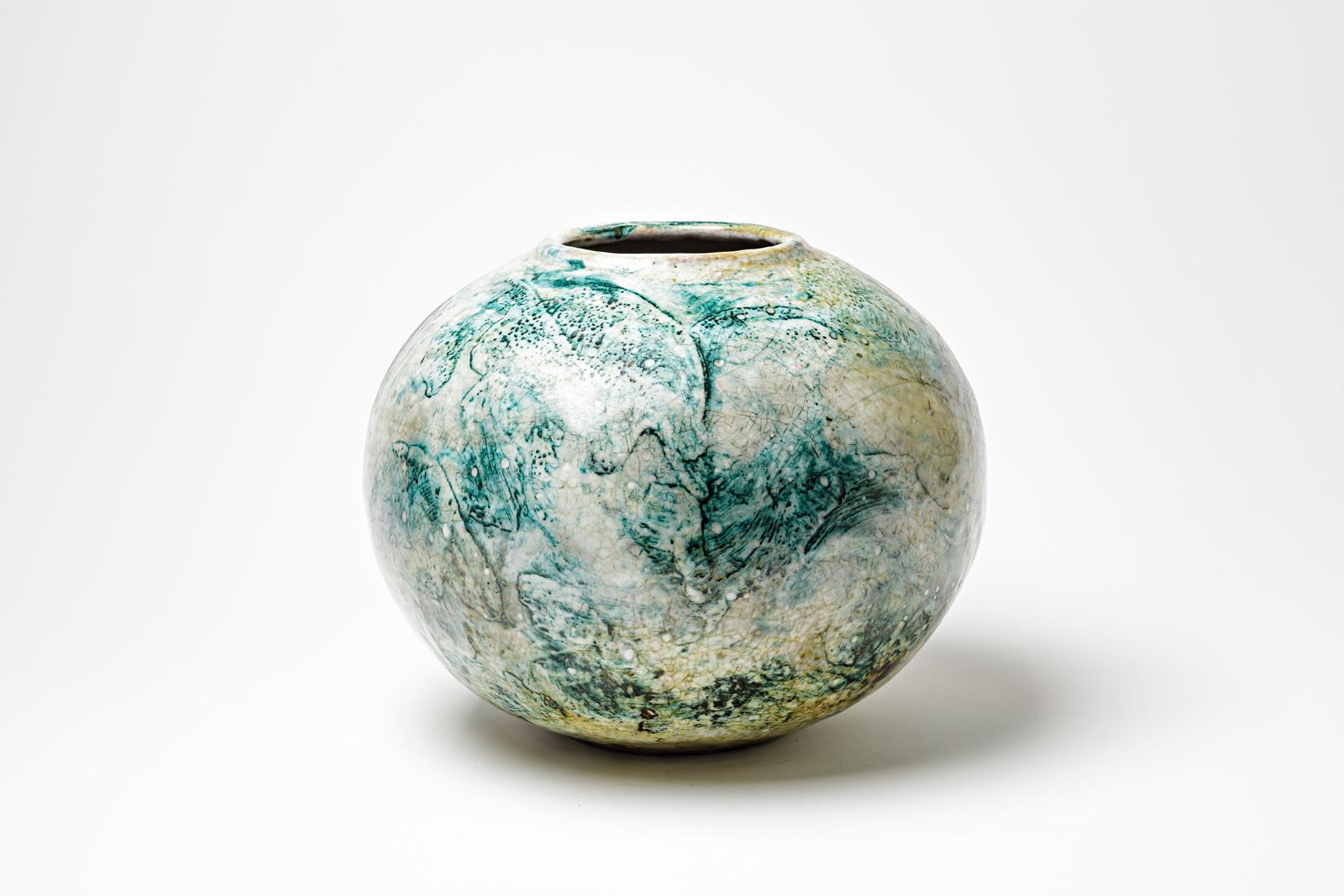 Green/blue and white glazed ceramic vase by Gisèle Buthod Garçon.
Raku fired. Artist monogram and signature under the base. Circa 1980-1990. 
H : 10.2’ x 11.8’ inches.