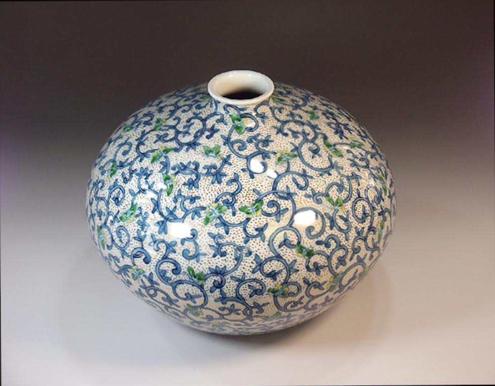 Exquisite hand painted Japanese contemporary porcelain vase created by acclaimed award-winning master artist from the Imari- Arita region of Japan, featuring a stunning arabesque pattern in vivid blue and green set against a white background with