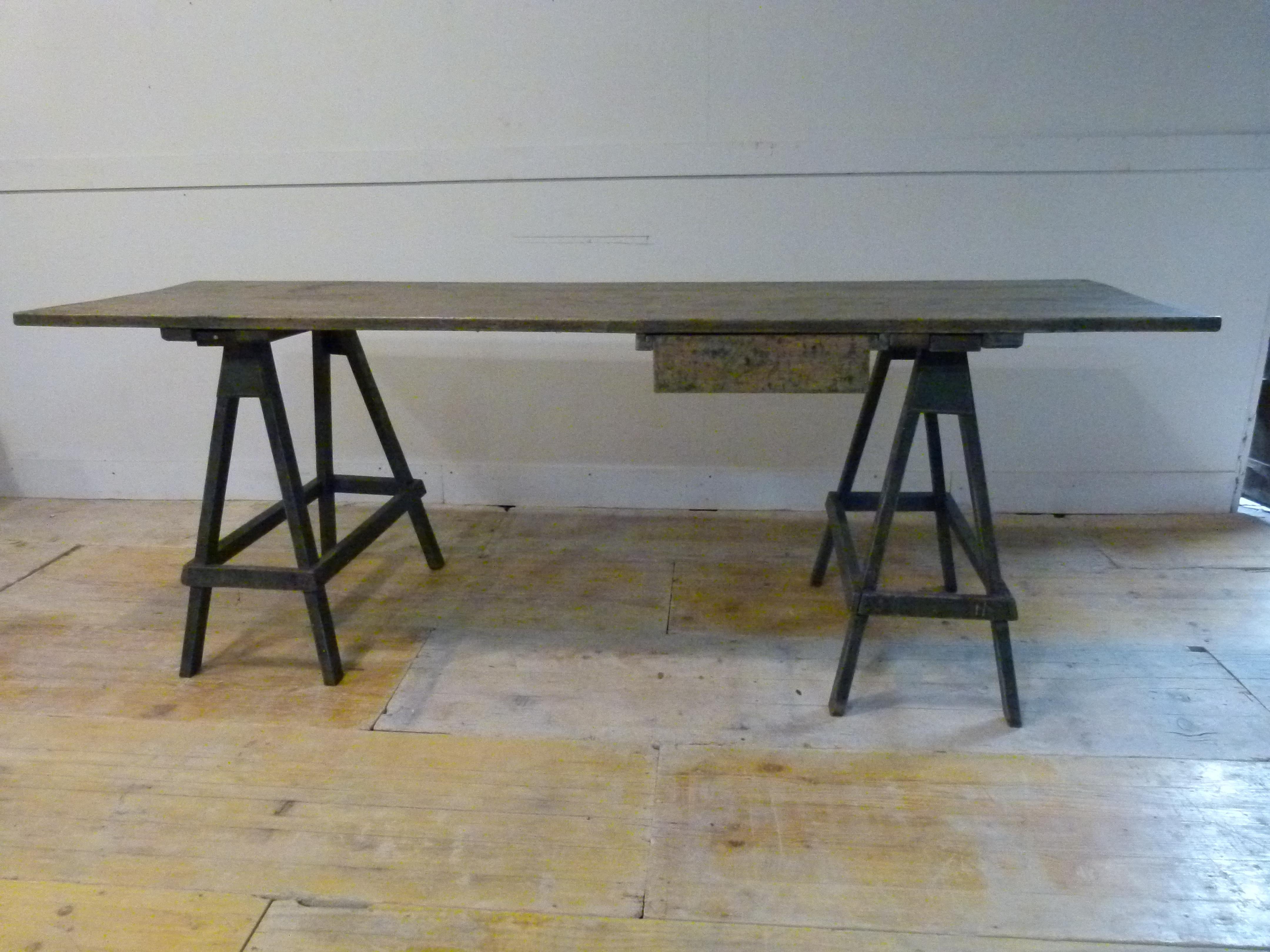 Niceold pine wood trestle table with a drawer on one of the sides. The trestles are adjusted to the guides bringing stability to the table. Blue nice patina.

Perfect for artist and bohemian ambients.
 