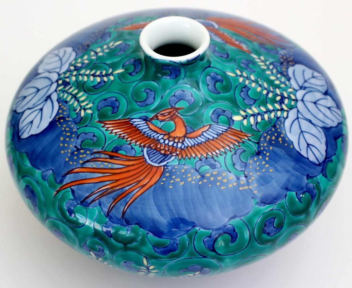 Contemporary Japanese decorative porcelain vase, hand painted in green, red and blue, showcasing phoenixes in vivid red and blue, set against a beloved dice- shaped porcelain body in a striking 
