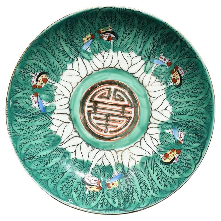 A brightly colored round ceramic bok choy motif trinket dish. This pretty famille verte chinoiserie dish is round in form and created from crisp white ceramic. The sides of the dish are painted with lush green bok choy or cabbage leaves. Small