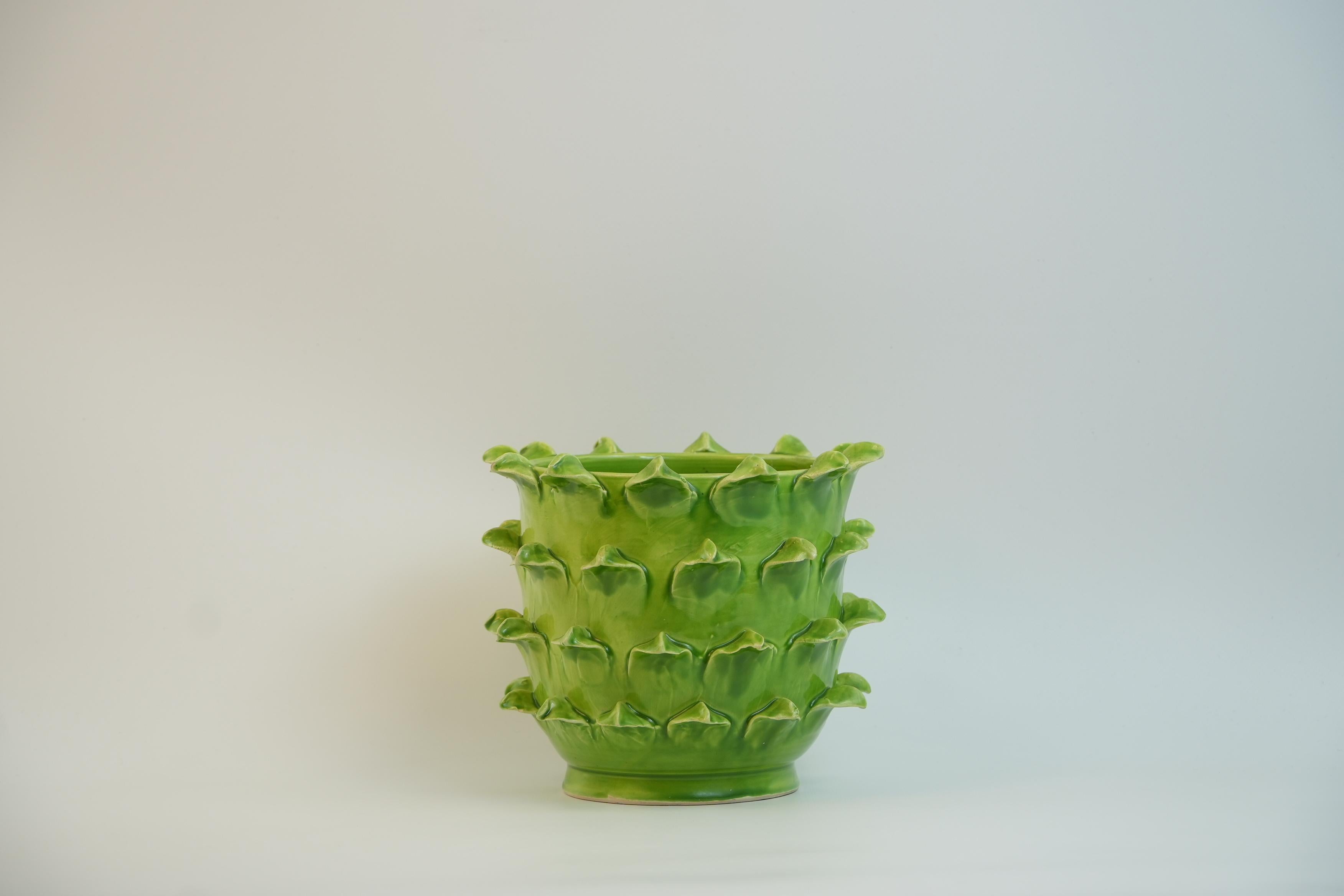Ce cache-pot en céramique vert vif du designer français Jean Roger a été fabriqué dans les années 1960. Son design unique se caractérise par une série de protubérances pointues, semblables à des feuilles, qui entourent le pot, créant ainsi une