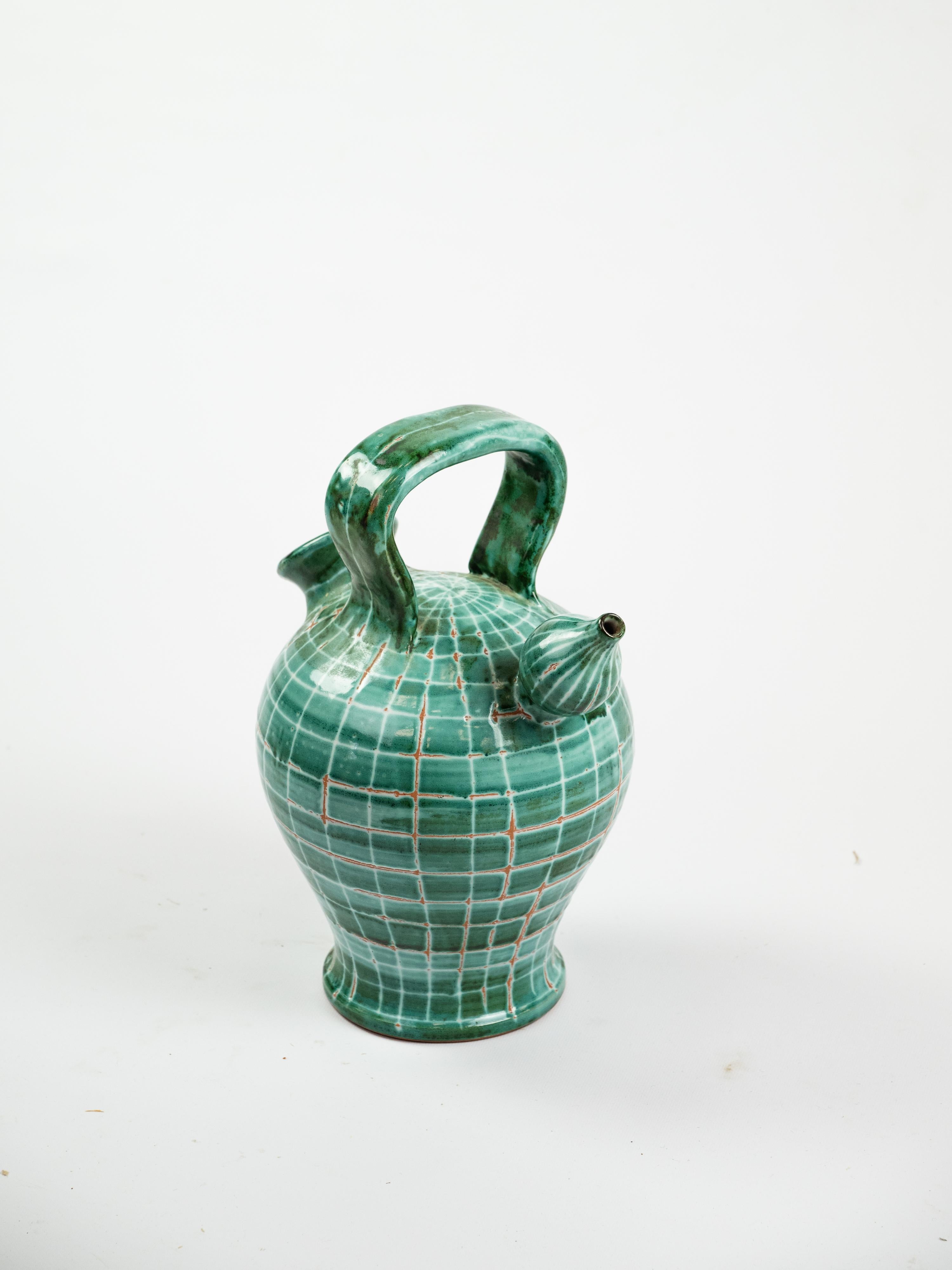 Cette gargoulette de Robert Picault incarne son style et sa fonctionnalité. Typiquement fabriqué en terre cuite, ce pichet à double anse présente un corps sphérique et un bec verseur, avec des motifs rythmiques audacieux dans les verts et les bruns.