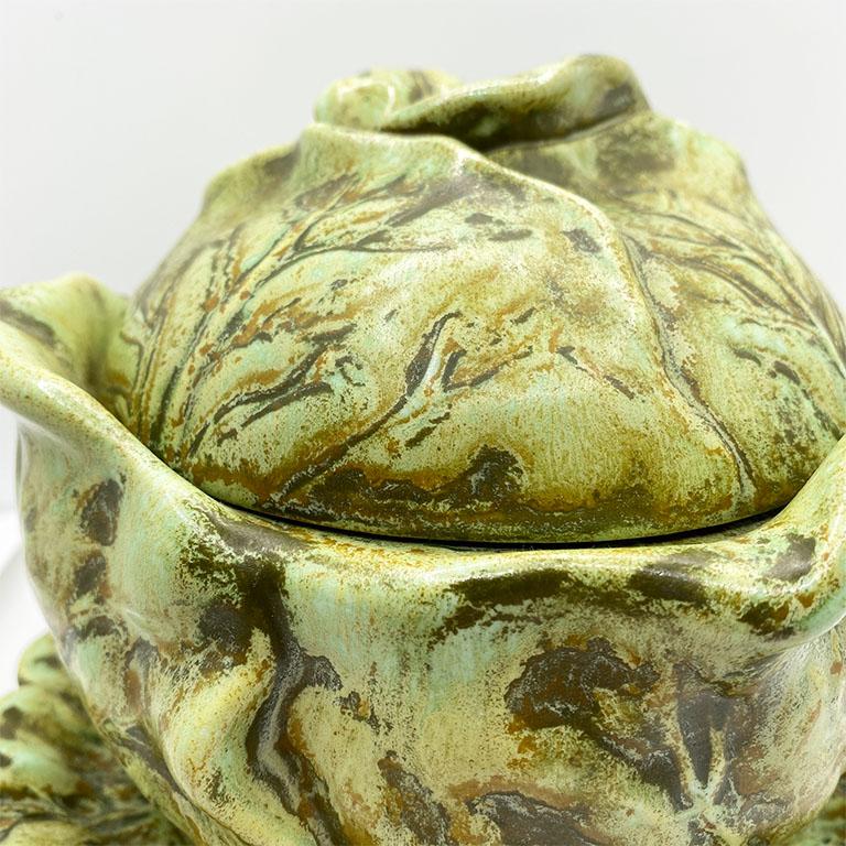 A muted green cabbage motif tureen with lid and serving saucer. This iconic pattern will be a great accent for your next dinner party. Slightly larger than a soup bowl, this piece will be great for serving smaller side dishes.

Dimensions:
5.5