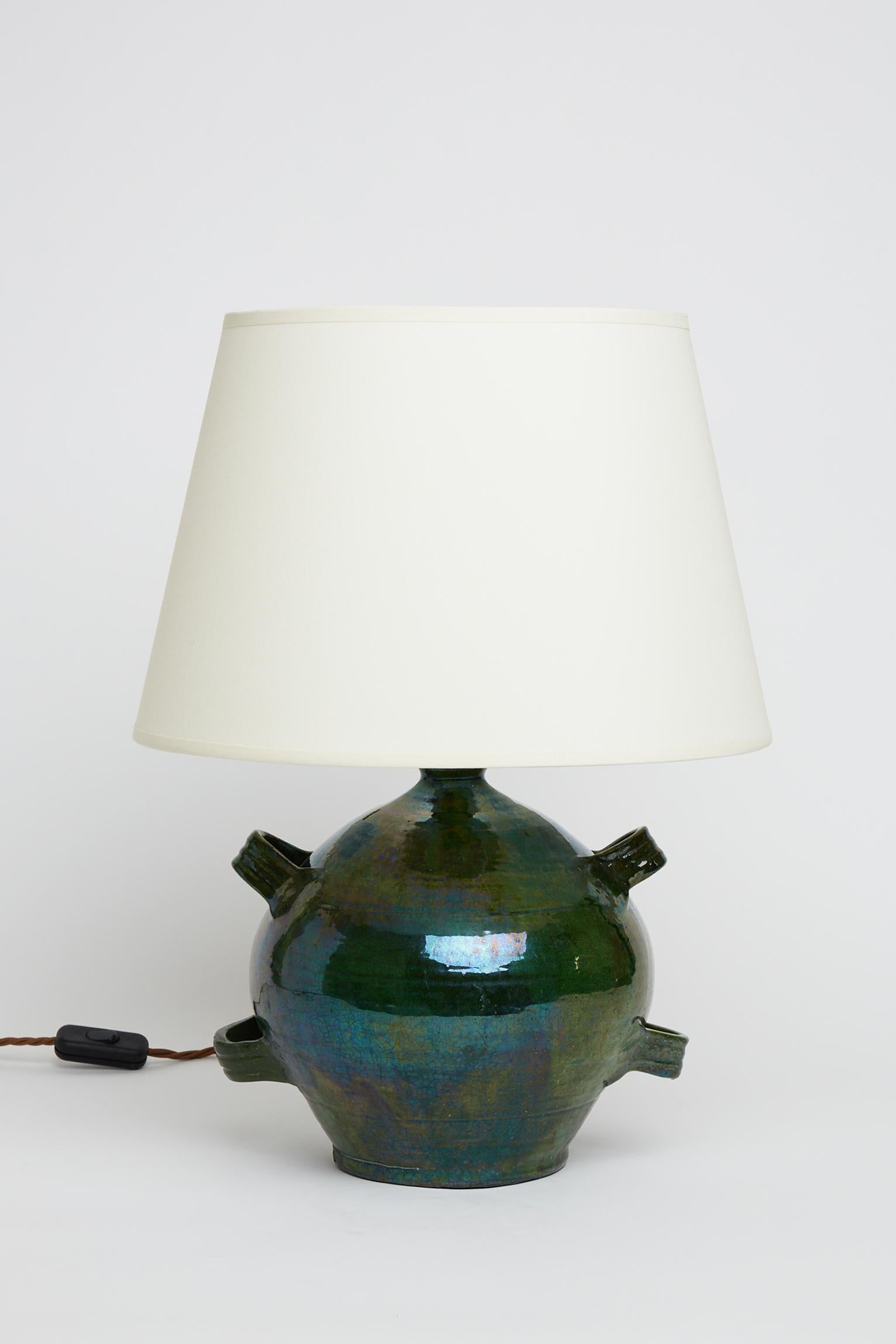 A green ceramic conscience jar converted into a table lamp.
France, early 20th century. 
Measures: With the shade: 49 cm high by 35 cm diameter.
Lamp base only: 33 cm high by 21 cm diameter.