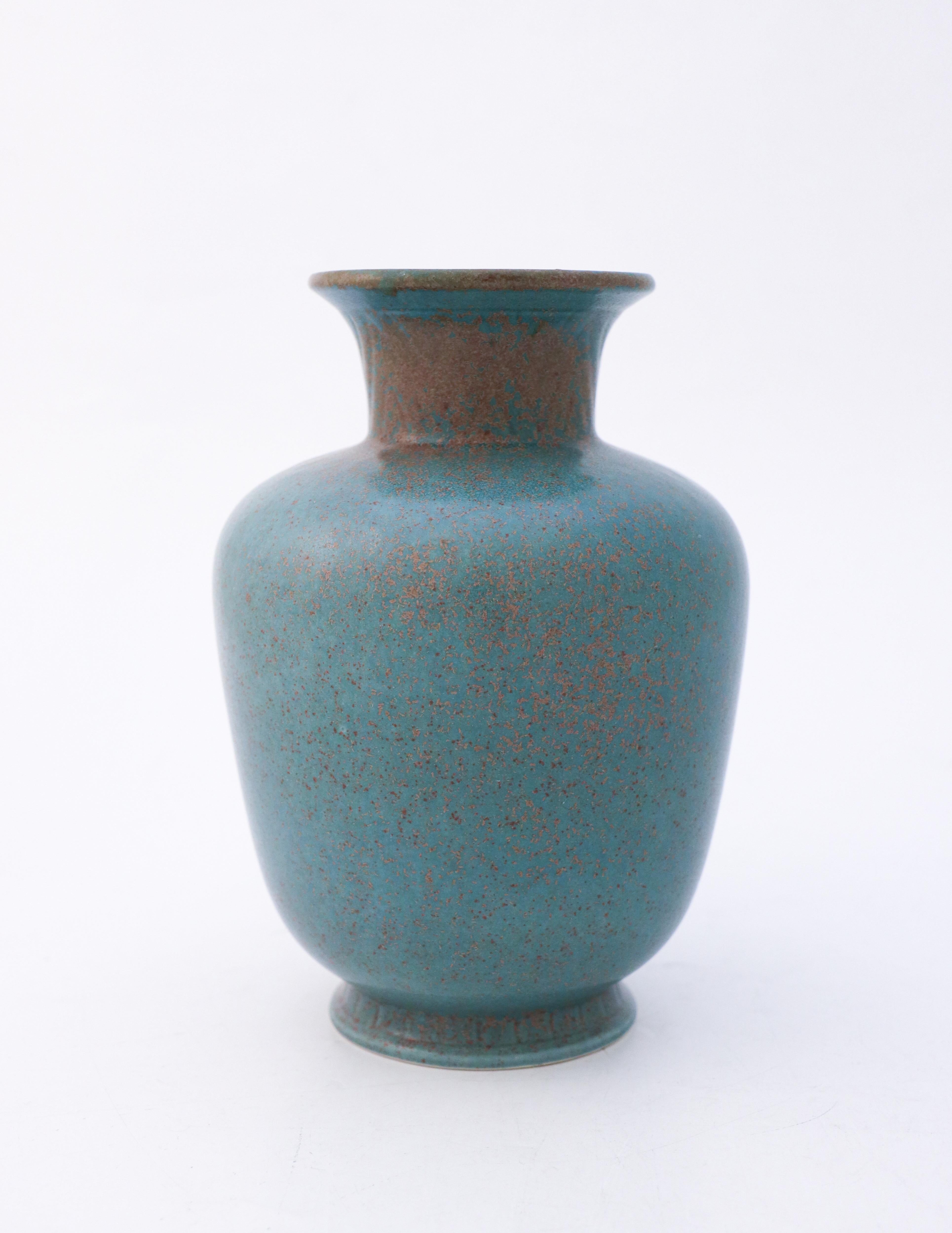 Eine Vase mit einer erstaunlichen grün / dunkel türkis gesprenkelten Glasur. Dies ist eine der beliebtesten Glasuren auf Gunnar Nylunds Keramiken. Die Vase wurde von Gunnar Nylund in Rörstrand im 20. Jahrhundert entworfen. Die Vase ist 19 cm hoch