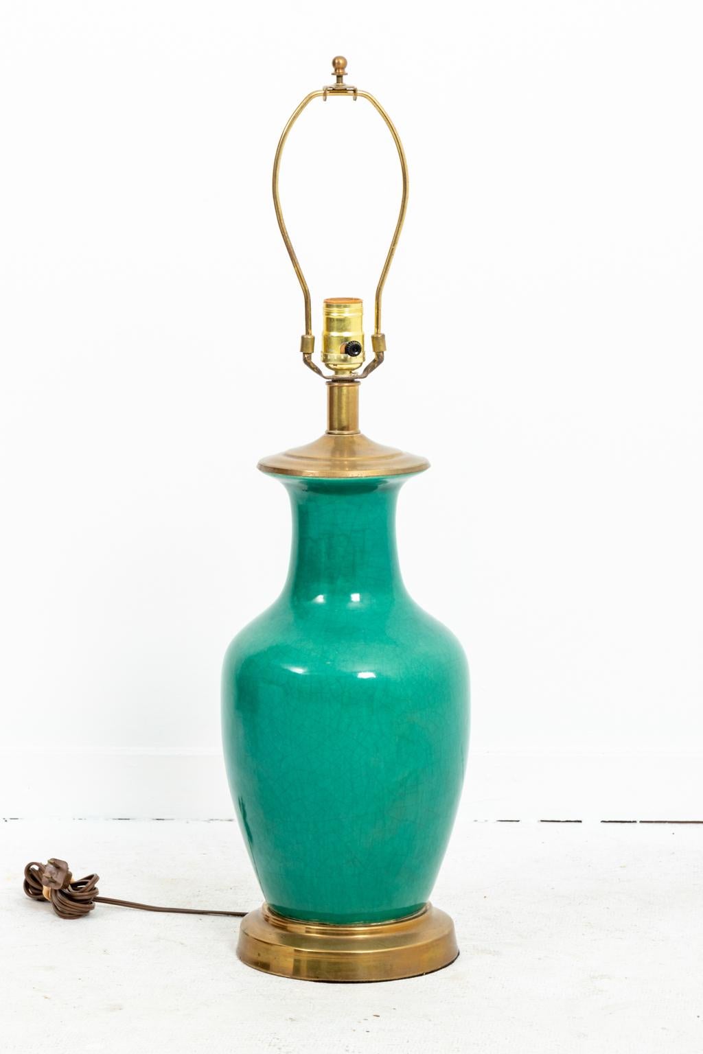 Green Chinese style ceramic vase repurposed as a table lamp with craquelure finish to glaze on brass base with brass cap, circa 1950s. Please note of wear consistent with age including minor pitting and tarnish to brass lamp base. Shade not included.